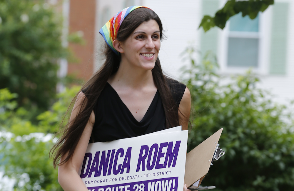 Democratic nominee for the House of Delegates 13th district seat, Danica Roem, brings campaign signs as she greets voters while canvasing a neighborhood Wednesday, June 21, 2017, in Manassas, Va. Roem is running against Del. Bob Marshall in the 13th House of Delegates District. (AP Photo/Steve Helber)