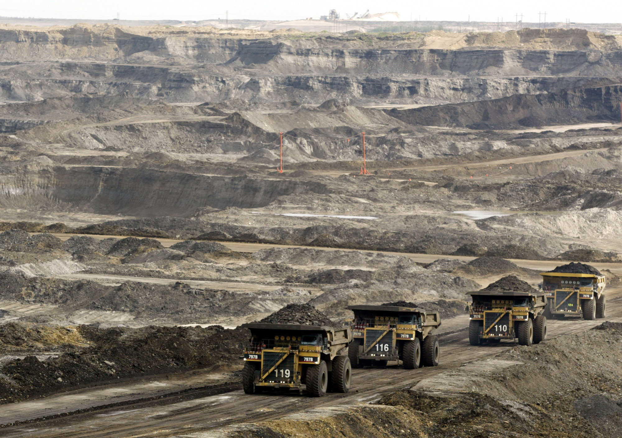 Mining trucks carry loads of oil laden sand at the Albian Sands oils sands project in Ft. McMurray, Alberta, Canada. (CREDIT: AP Photo/Jeff McIntosh)