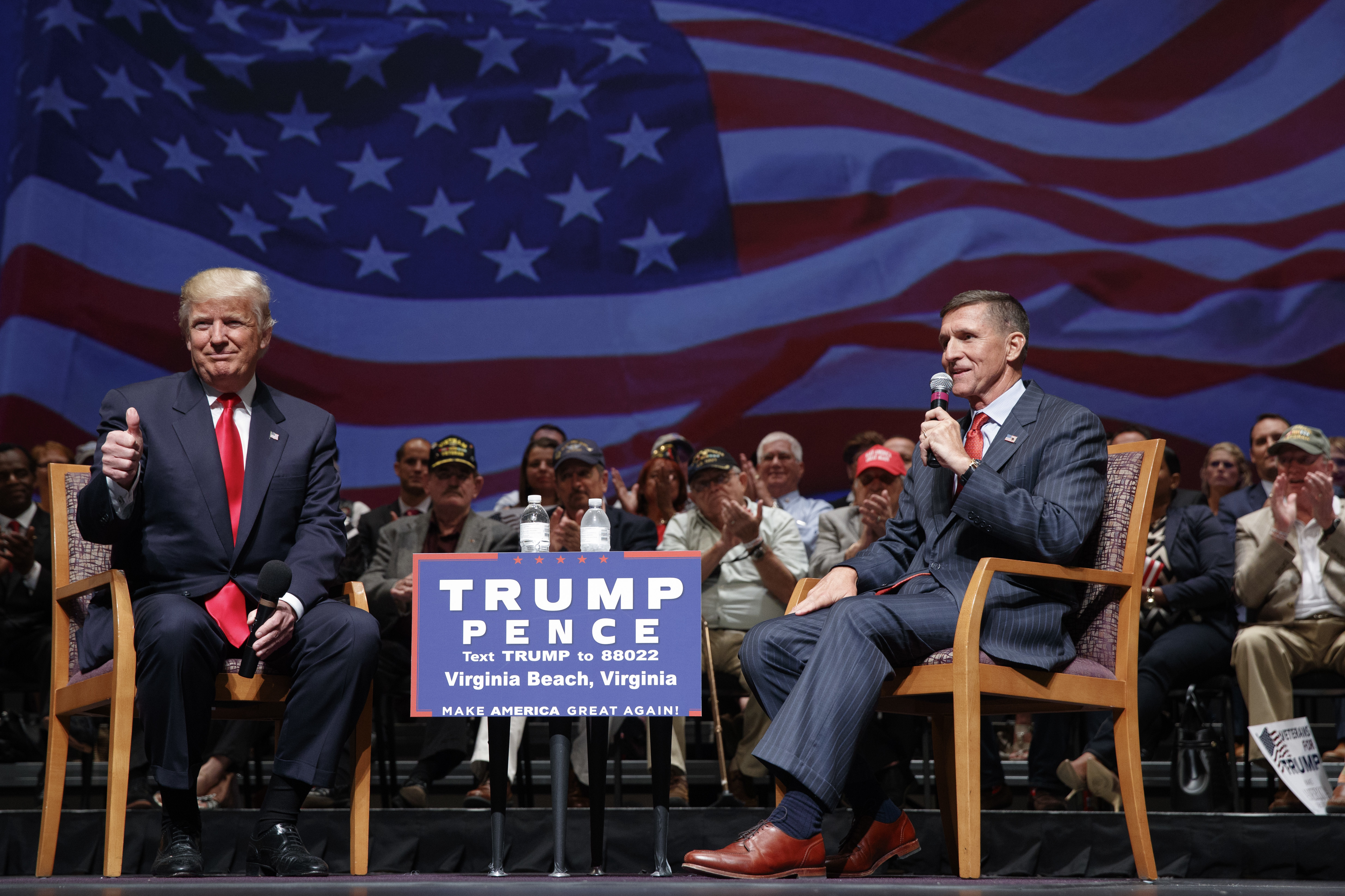 Donald Trump gives a thumbs-up as he speaks with retired Lt. Gen. Michael Flynn during a town hall in Virginia Beach, Va. (AP Photo/Evan Vucci, File)