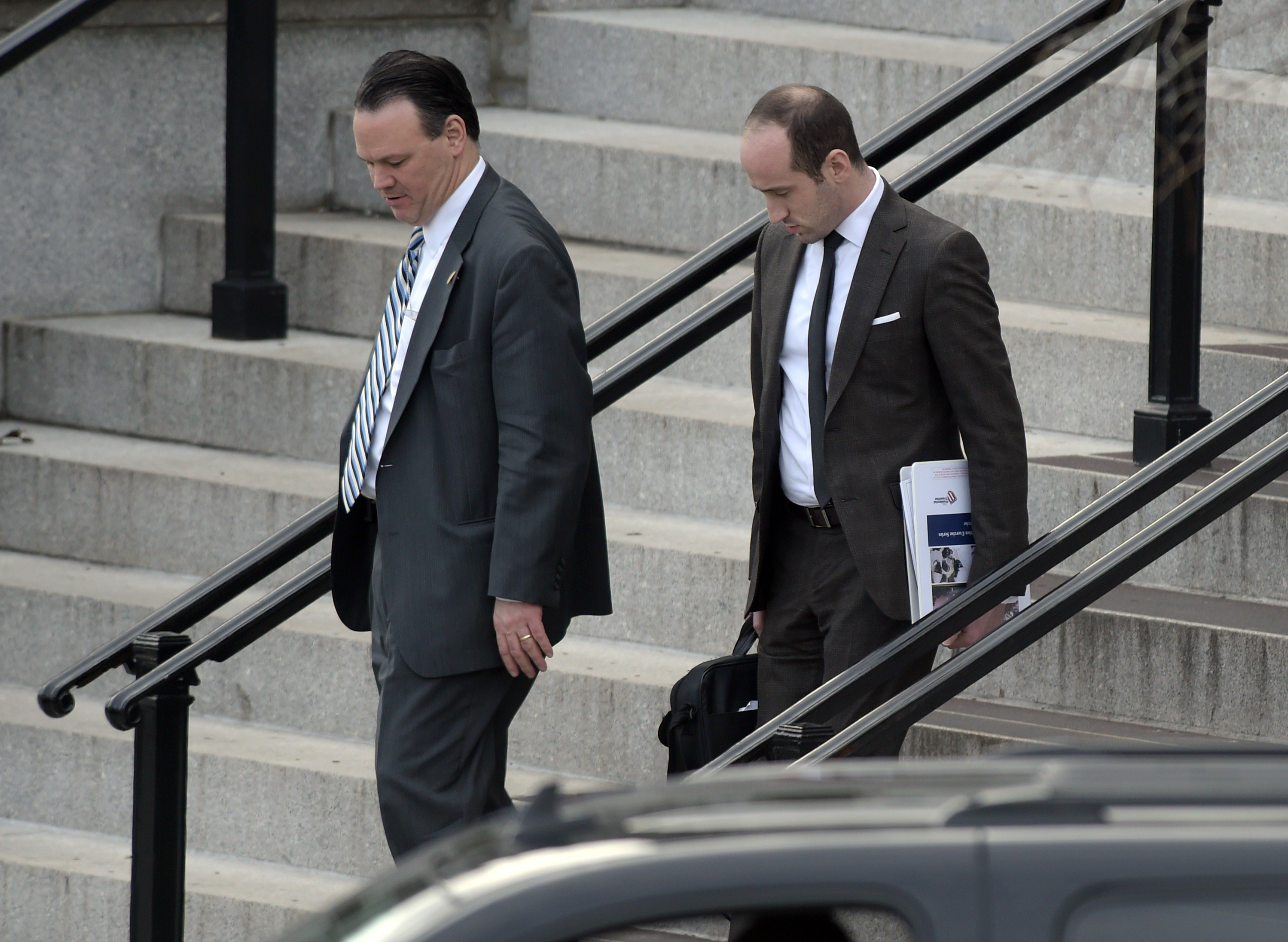 Trump deputy chief of staff for policy, Rick Dearborn, left, and senior policy adviser Stephen Miller, right, walk down the steps of the Eisenhower Executive Office Building on the White House complex in Washington, Friday, Jan. 13, 2017, following a meeting. CREDIT: AP Photo/Susan Walsh