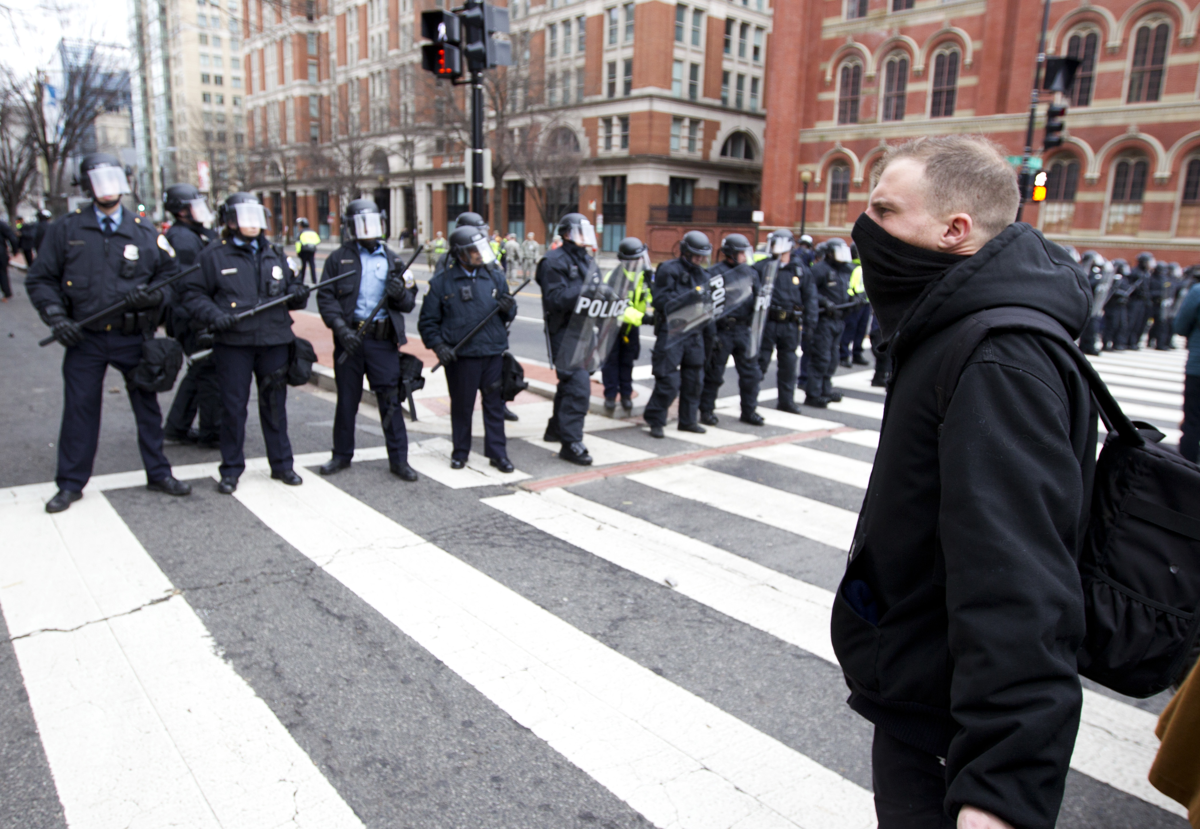 Protesters and cops on Inauguration Day in Washington, D.C., where federal prosecutors seek hundreds of felony convictions against people they acknowledge did not personally smash a window or assault an officer. CREDIT: AP Photo/Jose Luis Magana