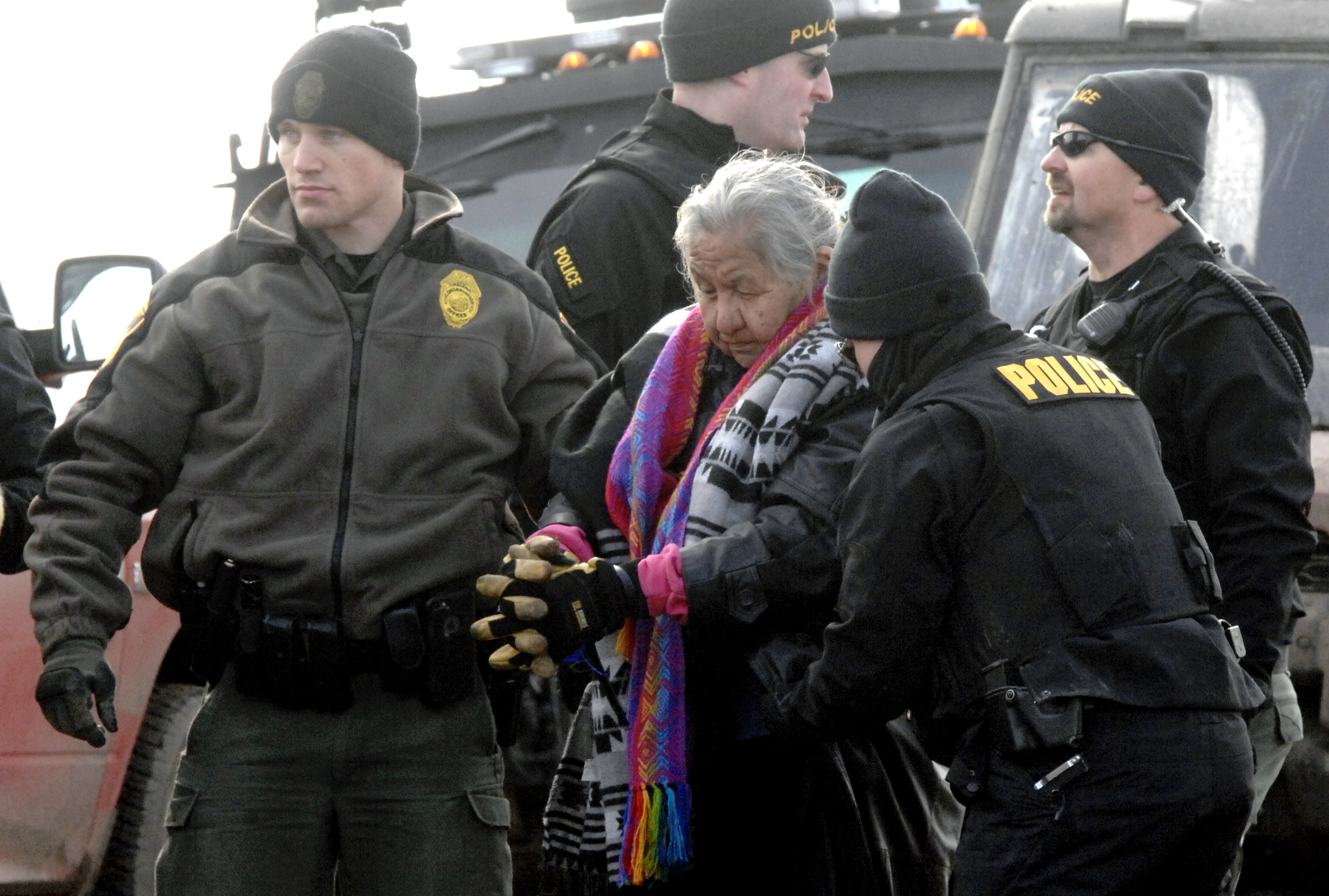 An elderly woman is escorted to a transport van after being arrested by law enforcement as part of the final sweep of the Dakota Access pipeline protesters. (CREDIT: Mike McCleary/The Bismarck Tribune via AP, Pool)