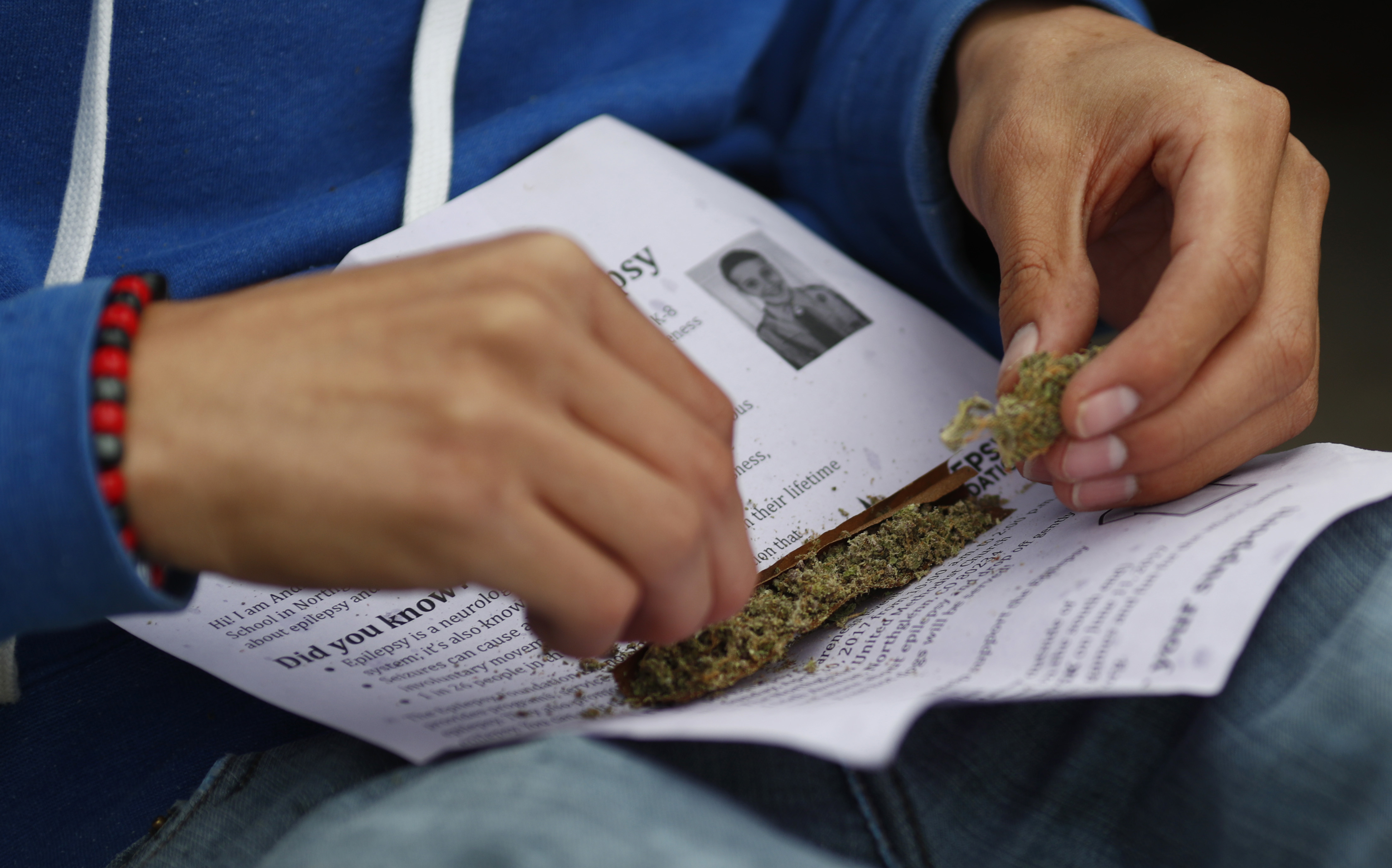 A marijuana enthusiast rolls a joint to light up at 4:20 p.m. MDT to mark the 4/20 holiday on Thursday, April 20, 2017, in Denver's Civic Center Park. (CREDIT: AP Photo/David Zalubowski)
