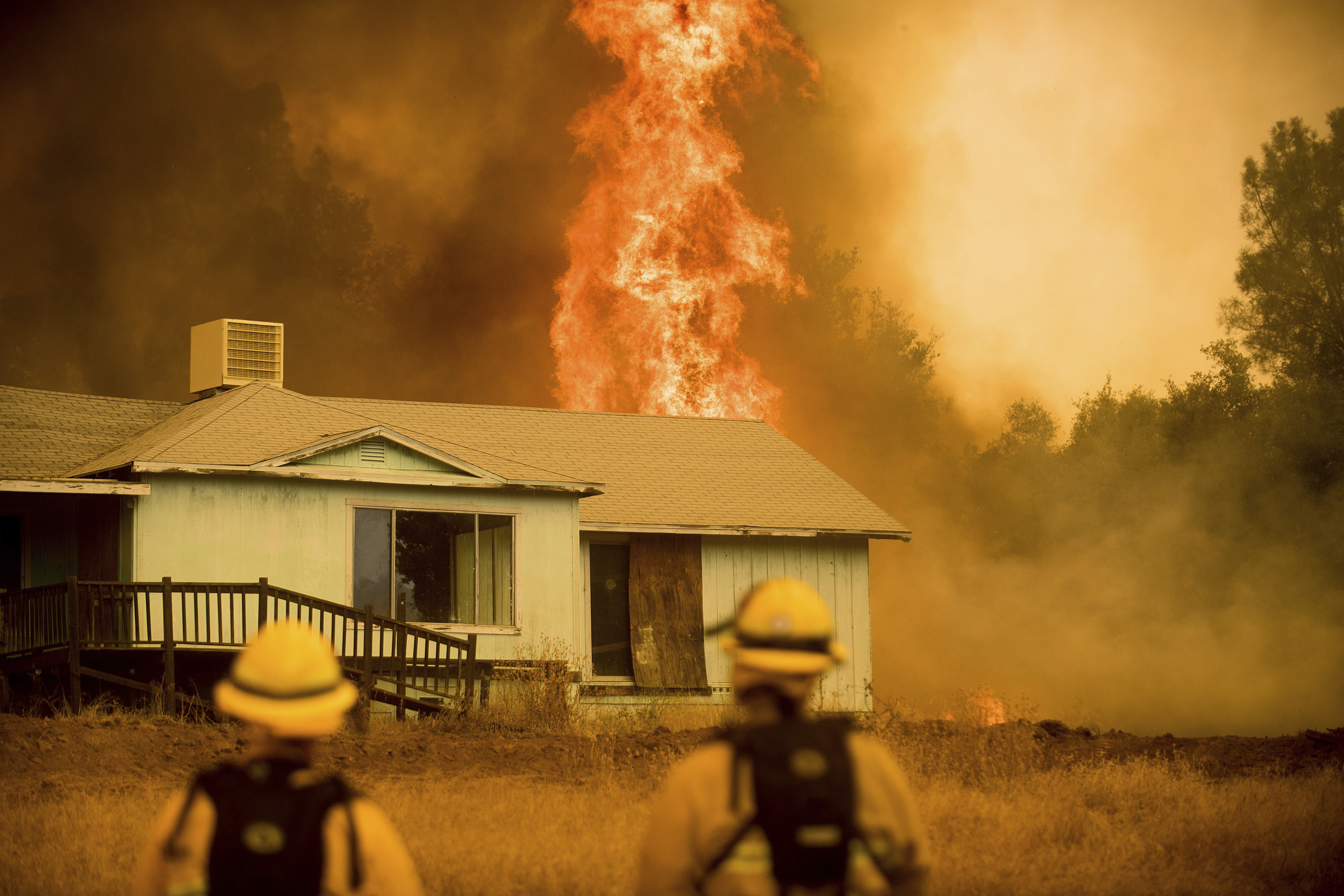Flames rise behind a vacant house as firefighters work to halt the Detwiler fire near Mariposa, CA, Wednesday, July 19, 2017. (CREDIT: AP Photo/Noah Berger)