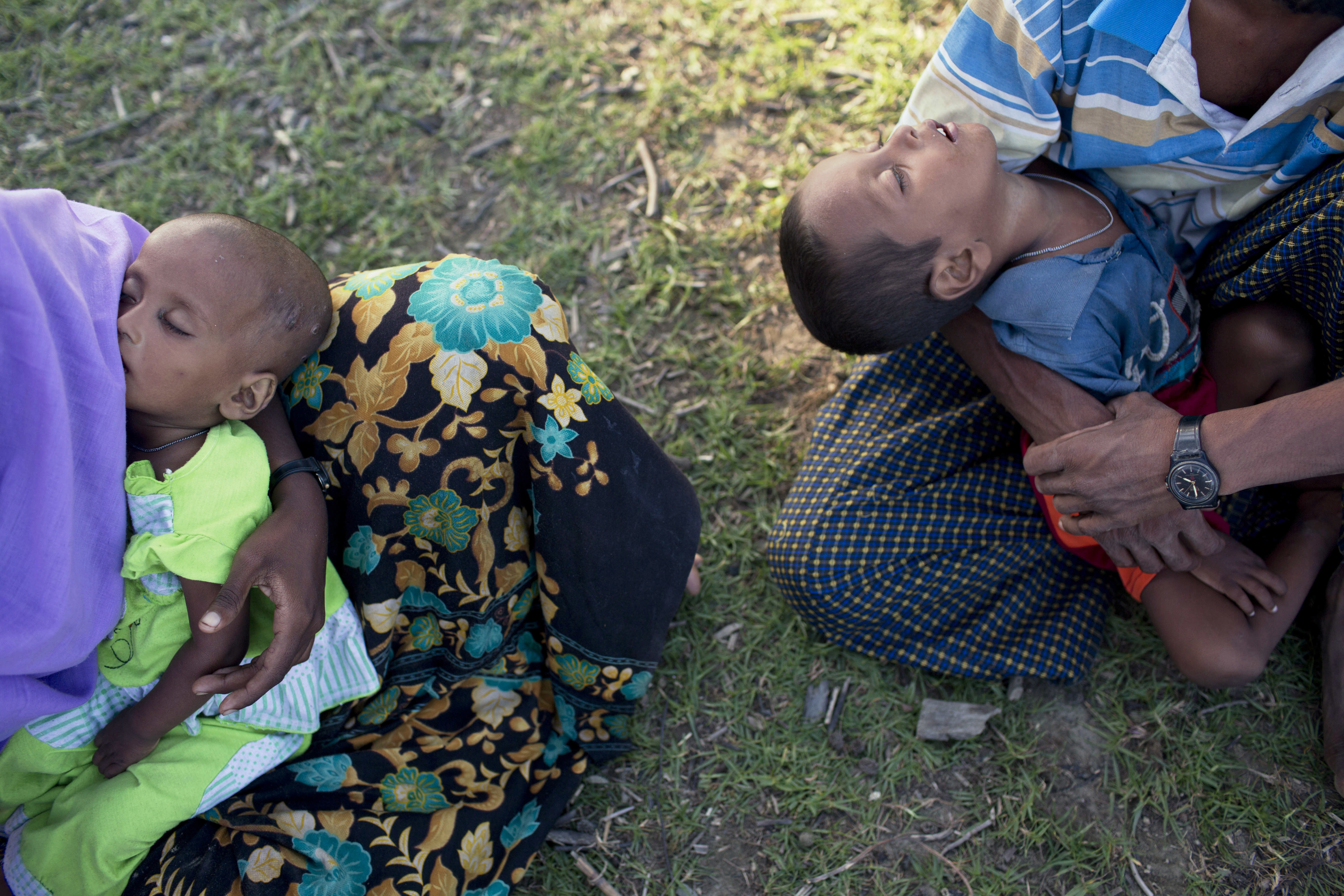 Newly arrived Rohingya Muslims from Myanmar carry children and rest after having just crossed over the border, as they wait for permission to proceed towards a refugee camp near Ukhiya, Bangladesh, Friday, Nov. 10, 2017. U.N. CREDIT: A.M. Ahad/AP Photo.