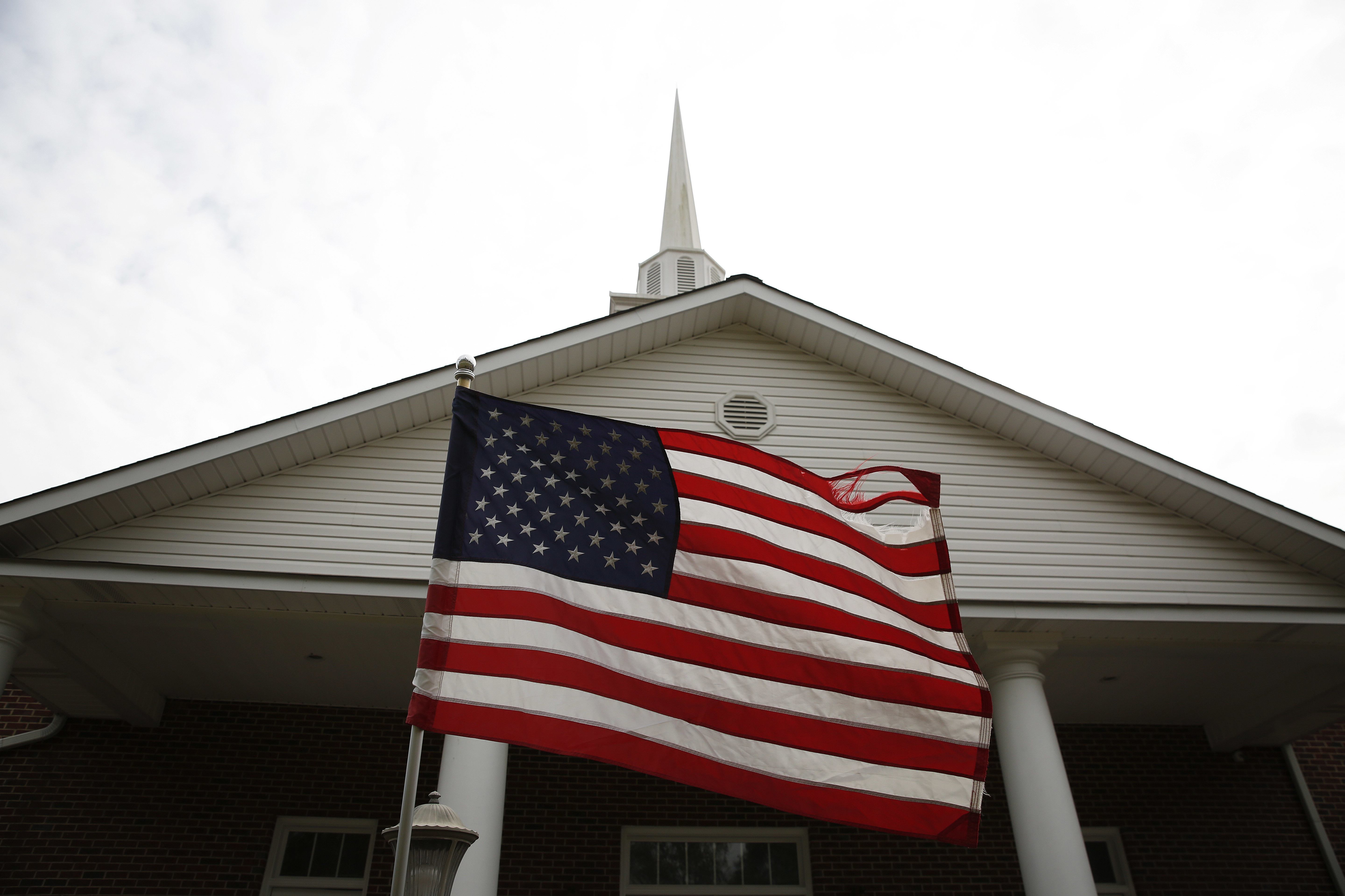 A weathered American flag flies in front of the First Baptist Church of Gallant, Sunday, Nov. 12, 2017, in Gallant, Ala. CREDIT: AP Photo/Brynn Anderson