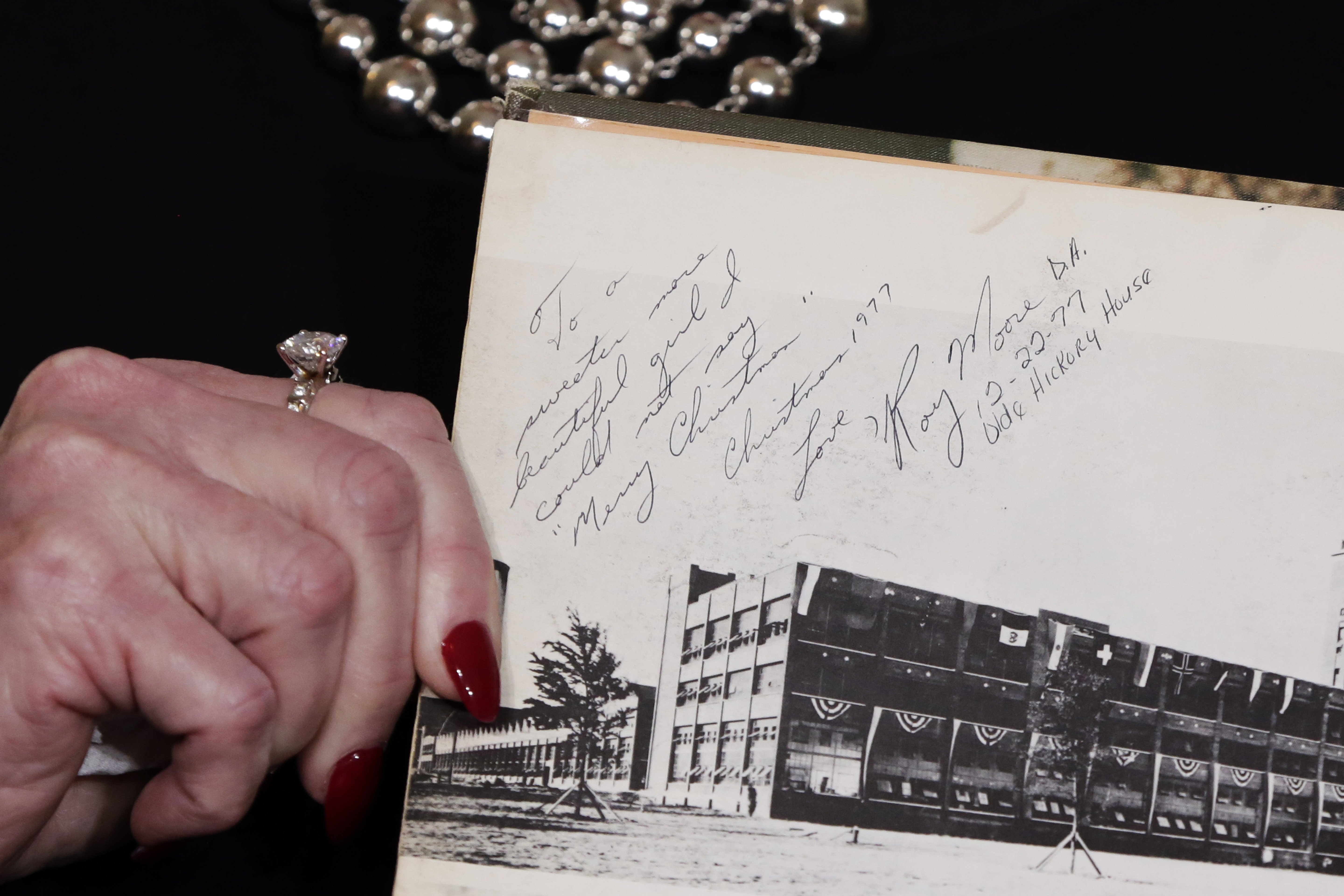 Beverly Young Nelson the latest accuser of Alabama Republican Roy Moore, shows her high school yearbook signed by Moore, at a news conference, in New York, Monday, Nov. 13, 2017. Nelson says Moore assaulted her when she was 16 and he offered her a ride home from a restaurant where she worked. Anticipating Nelson's allegations at the news conference, Moore's campaign ridiculed her attorney, Gloria Allred, beforehand as "a sensationalist leading a witch hunt." (AP Photo/Richard Drew)