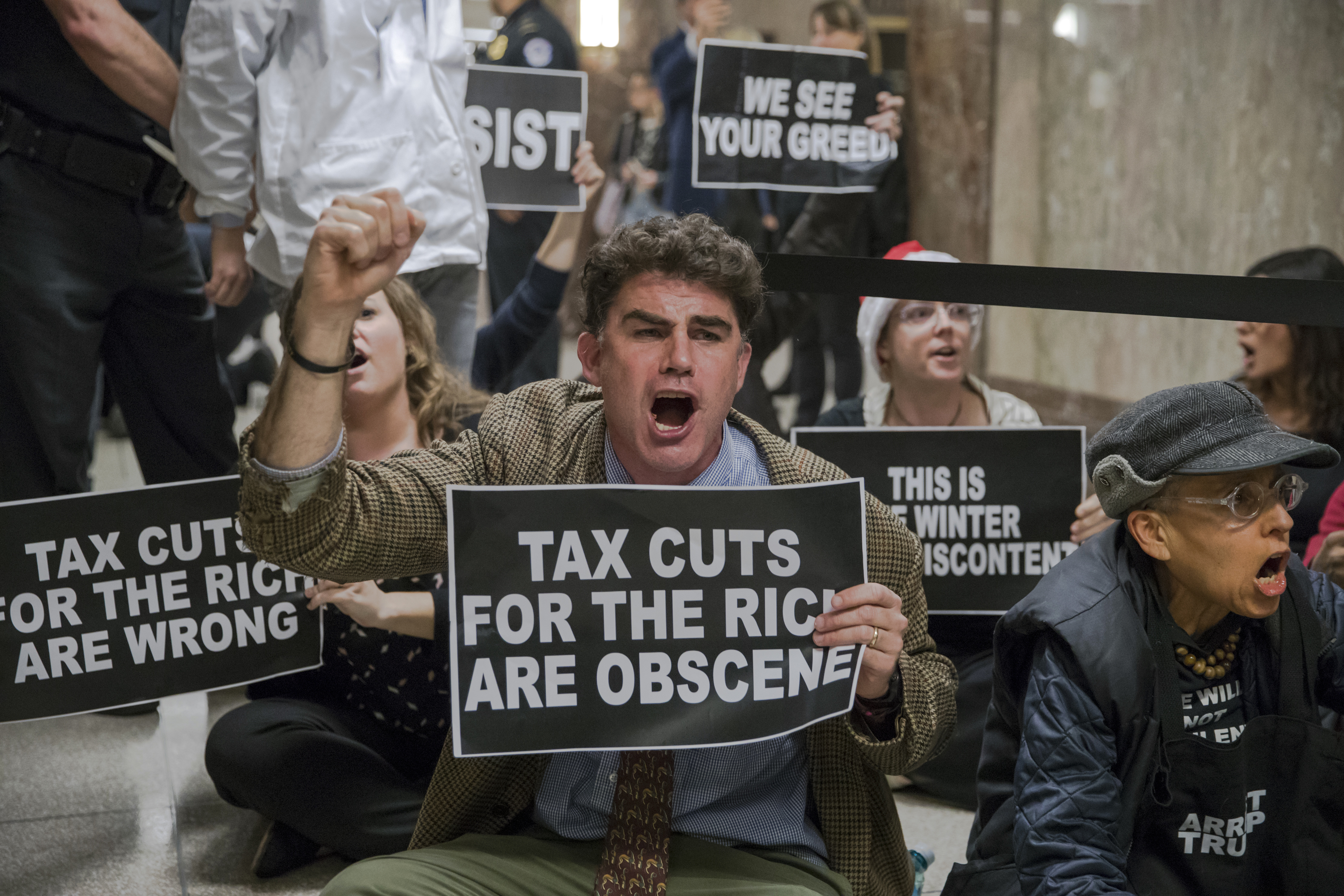 Protesters shout their disapproval of the Republican tax bill outside the Senate Budget Committee hearing room on Capitol Hill in Washington, Tuesday, Nov. 28, 2017. CREDIT: AP Photo/J. Scott Applewhite
