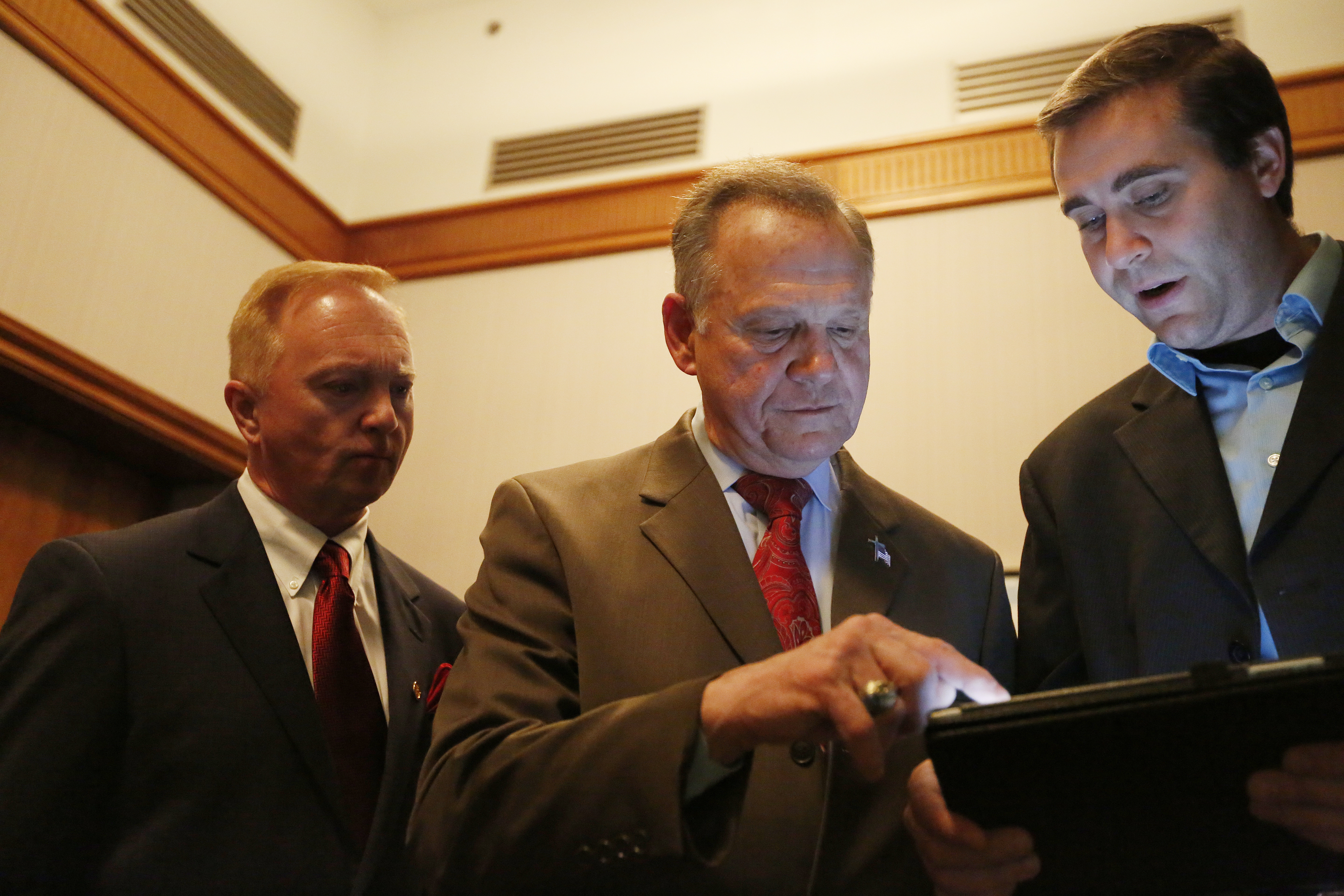 Roy Moore, center, huddles with staffers on election night. CREDIT: AP Photo/Brynn Anderson