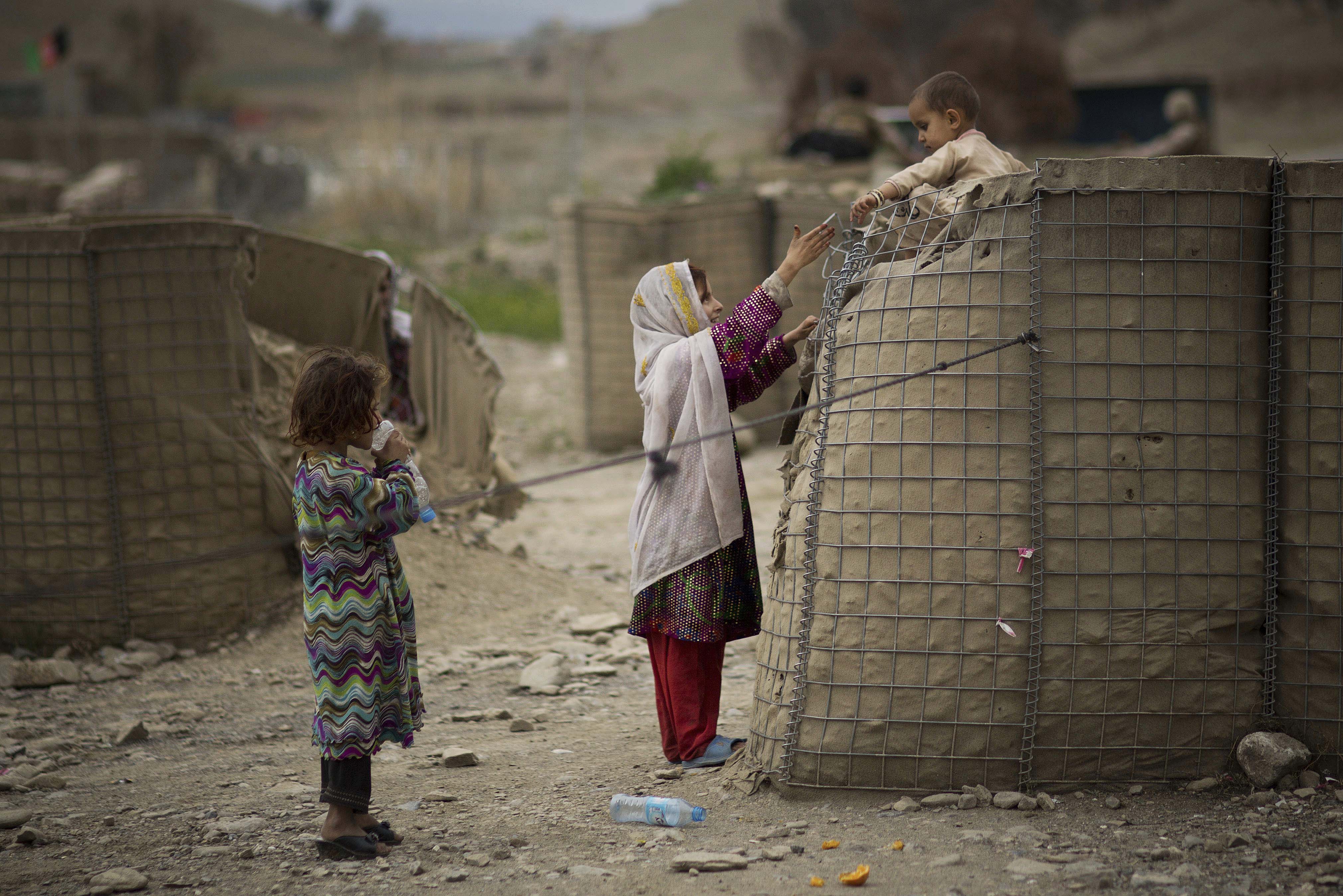 A girl helps her brother down from a security barrier in the eastern Afghanistan city of Khost, April 3, 2014. (CREDIT: AP Photo/Anja Niedringhaus)