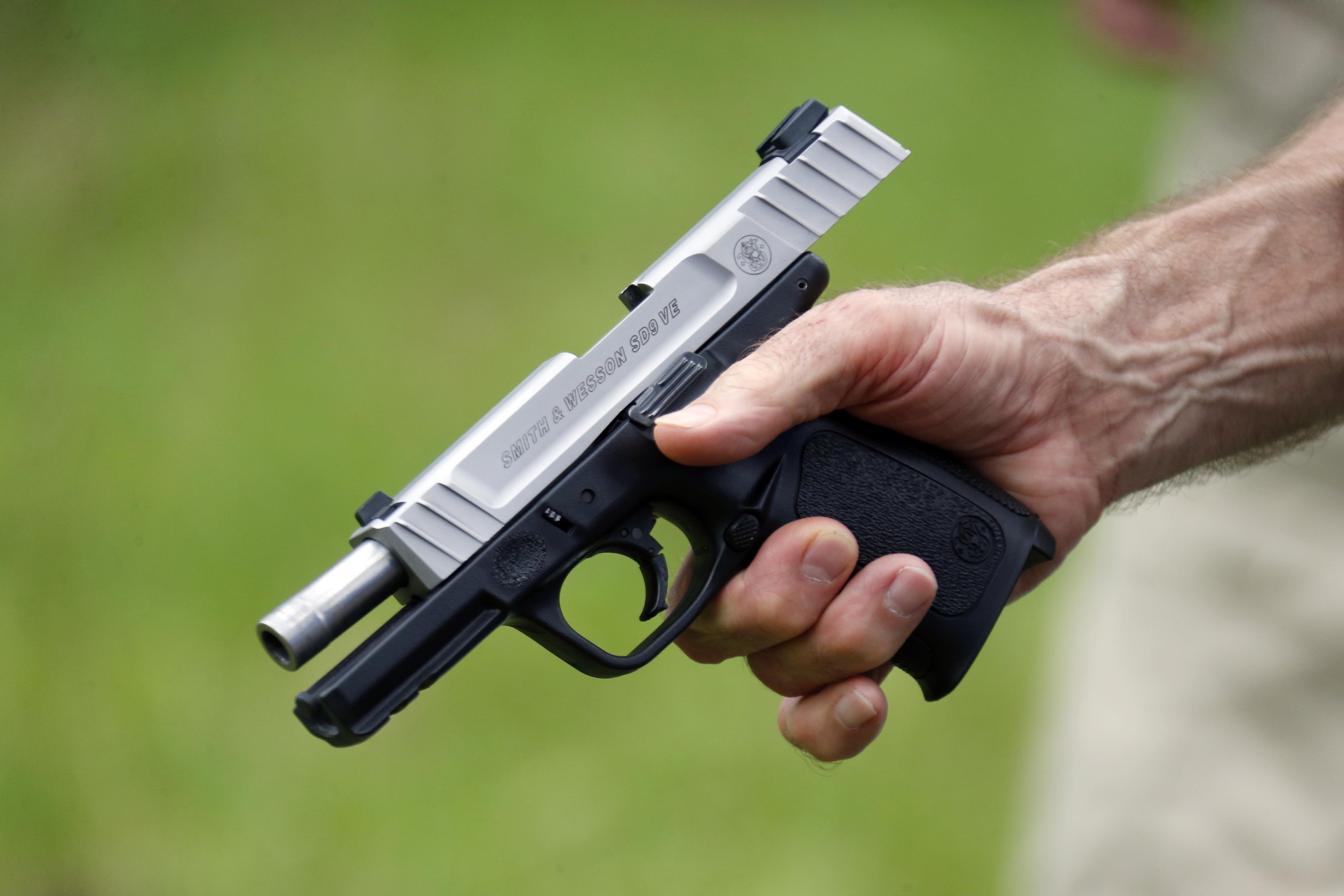 In this April 30, 2016 photograph, a participant holds his recently emptied automatic away from his body during the live fire portion of a enhanced concealed carry class sponsored by Crestview Baptist Church for members and area residents in Petal, Miss. The 20 participants received hands on assistance during a practical shooting exercise, a thorough review on the fundamentals of safe handling of firearms in addition to a review of the basic and enhanced Mississippi Concealed Carry laws. (AP Photo/Rogelio V. Solis)