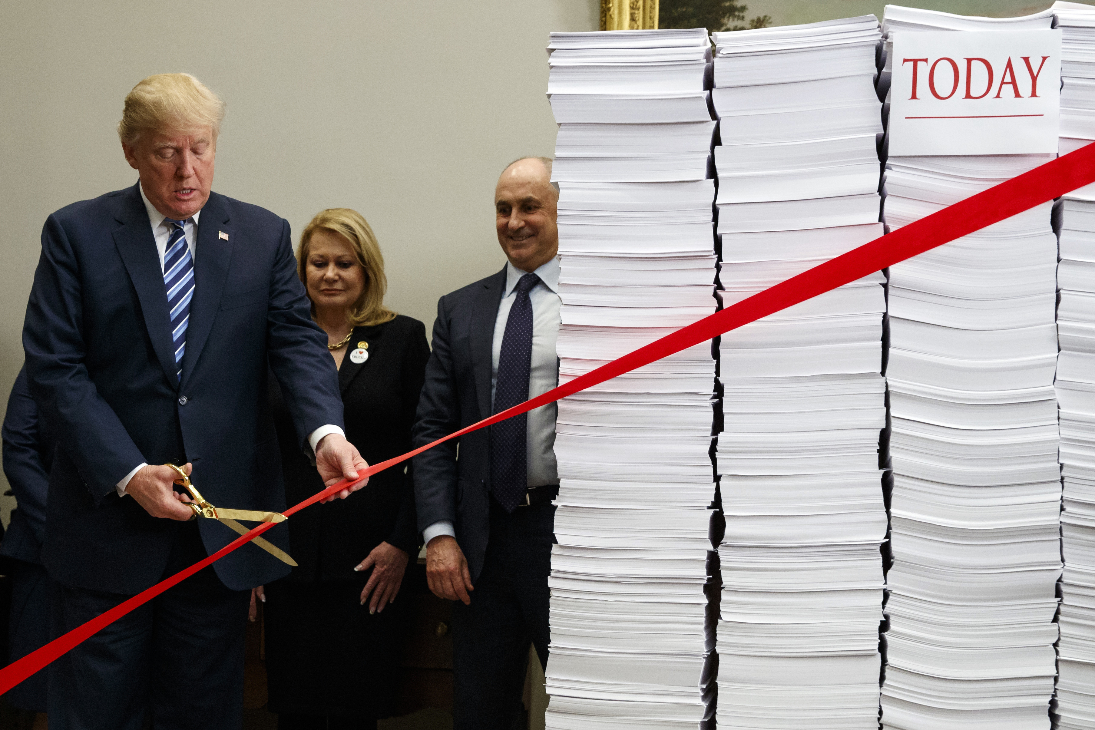 President Donald Trump cuts a ribbon during an event on federal regulations at the White House on December 14, 2017. CREDIT: AP Photo/Evan Vucci