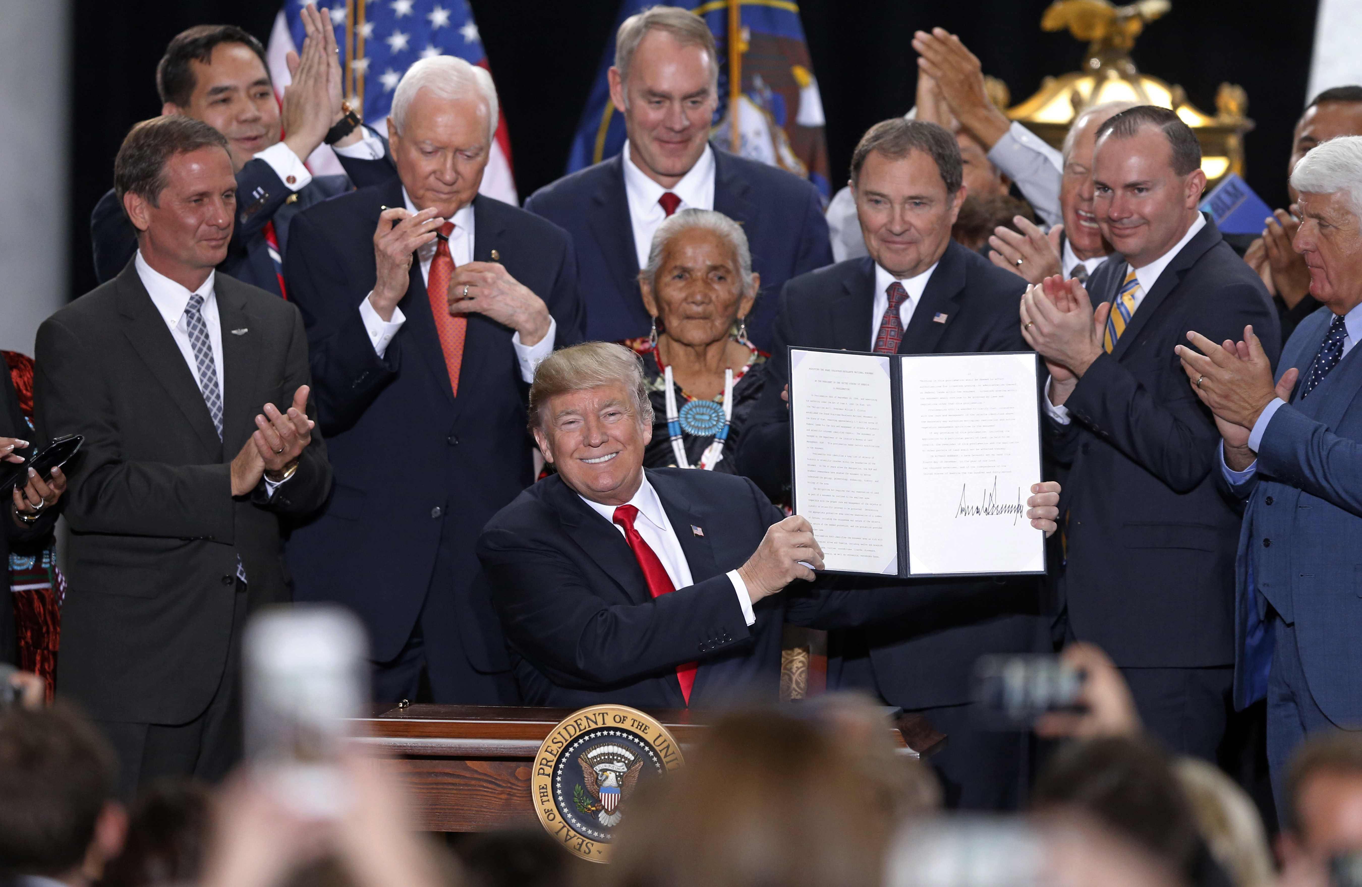 President Donald Trump holds up a signed proclamation to shrink the size of Bears Ears national monument at the Utah State Capitol on December 4, 2017, in Salt Lake City. CREDIT: Photo/Rick Bowmer