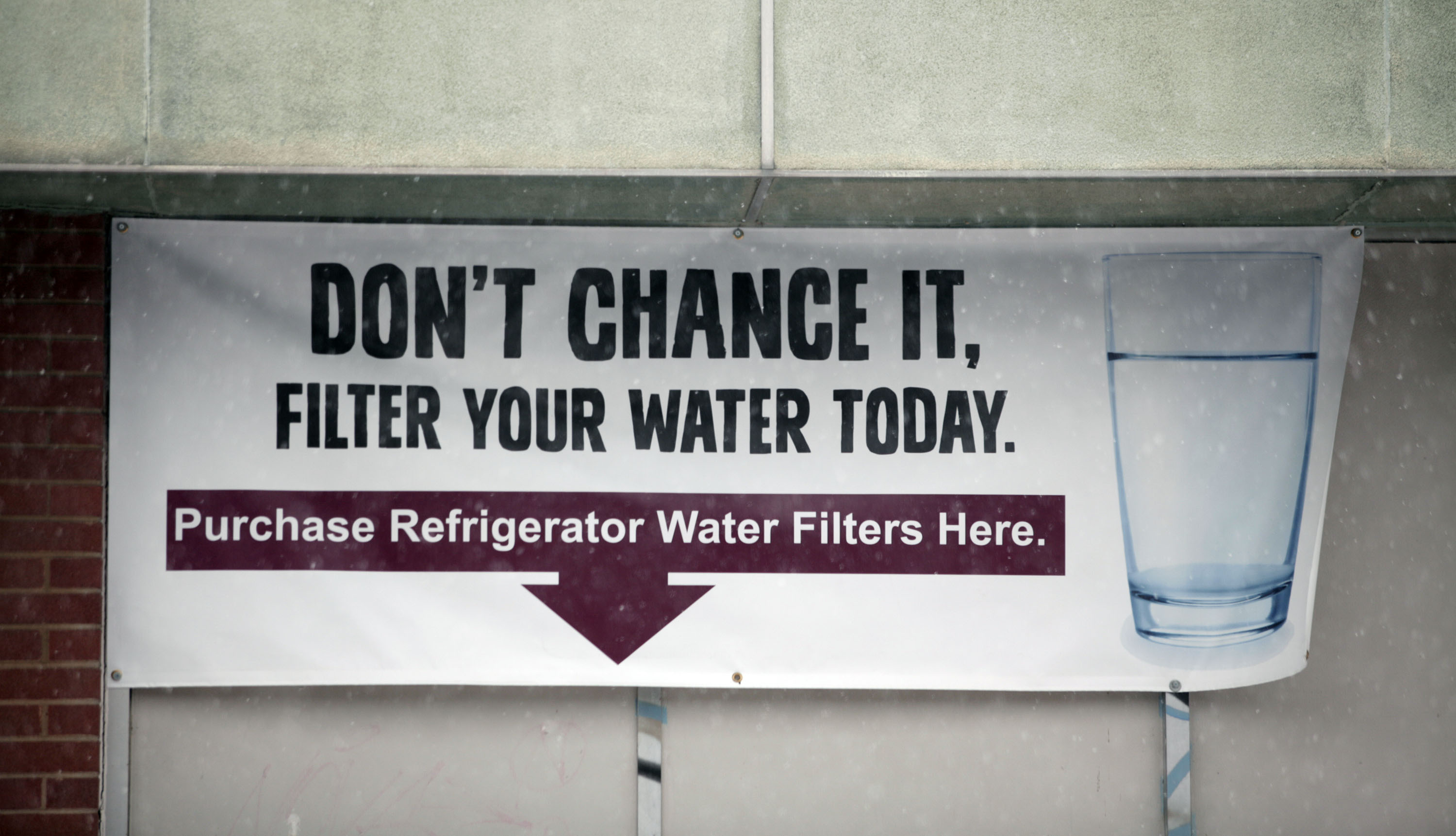 A sign on a the front of a building warns residents to filter their water January 17, 2016 in Flint, Michigan. CREDIT: Bill Pugliano/Getty Images