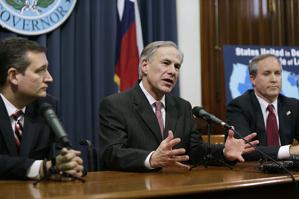 Texas Gov. Greg Abbott (R) speaks alongside U.S. Sen. Ted Cruz (R-TX) (L), Attorney General Ken Paxton (R) at a 2015 press conference. (Photo by Erich Schlegel/Getty Images)