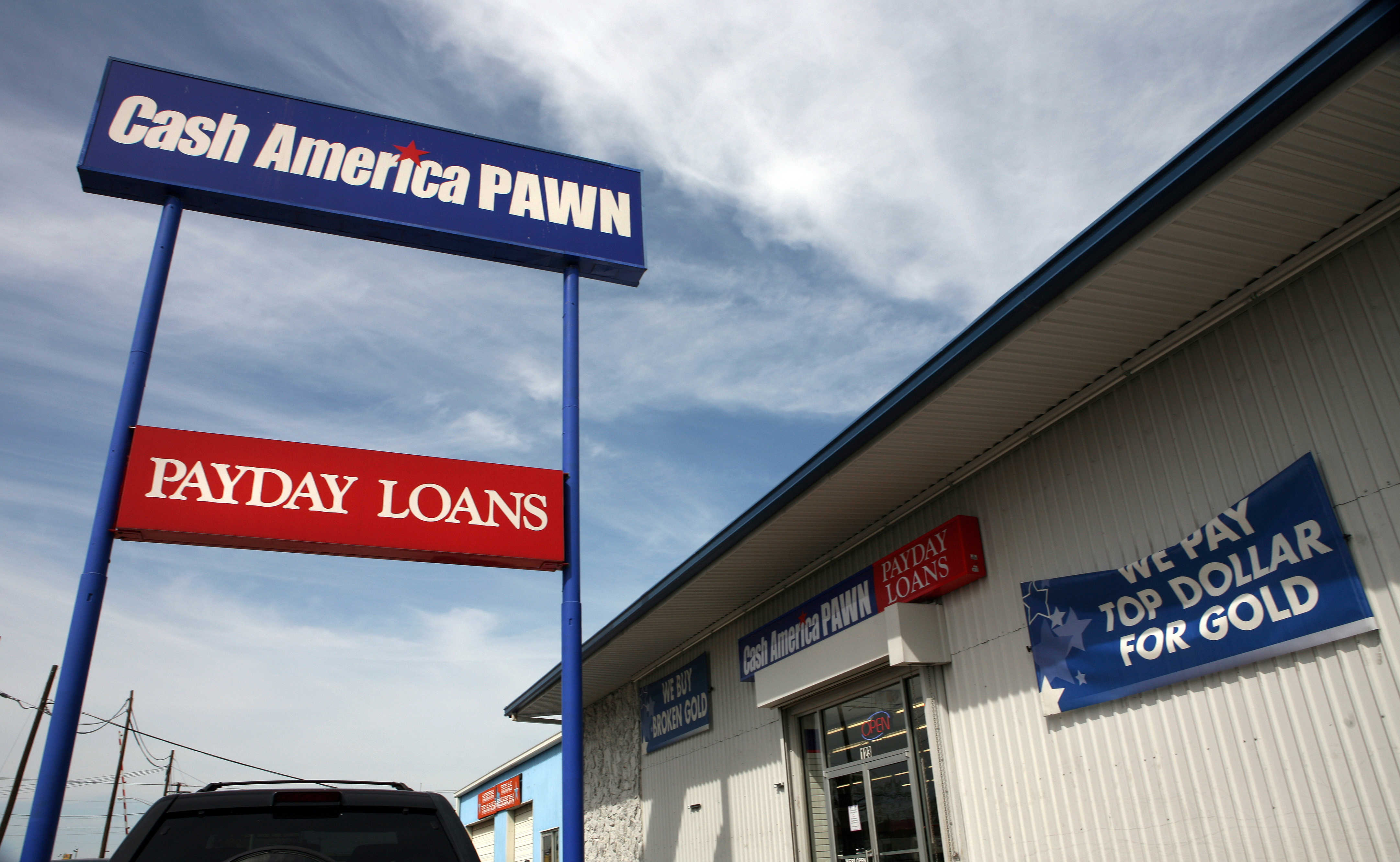 Signs at a Cash America pawn shop advertise payday loans and gold purchasing. CREDIT: David Woo/Corbis via Getty Images