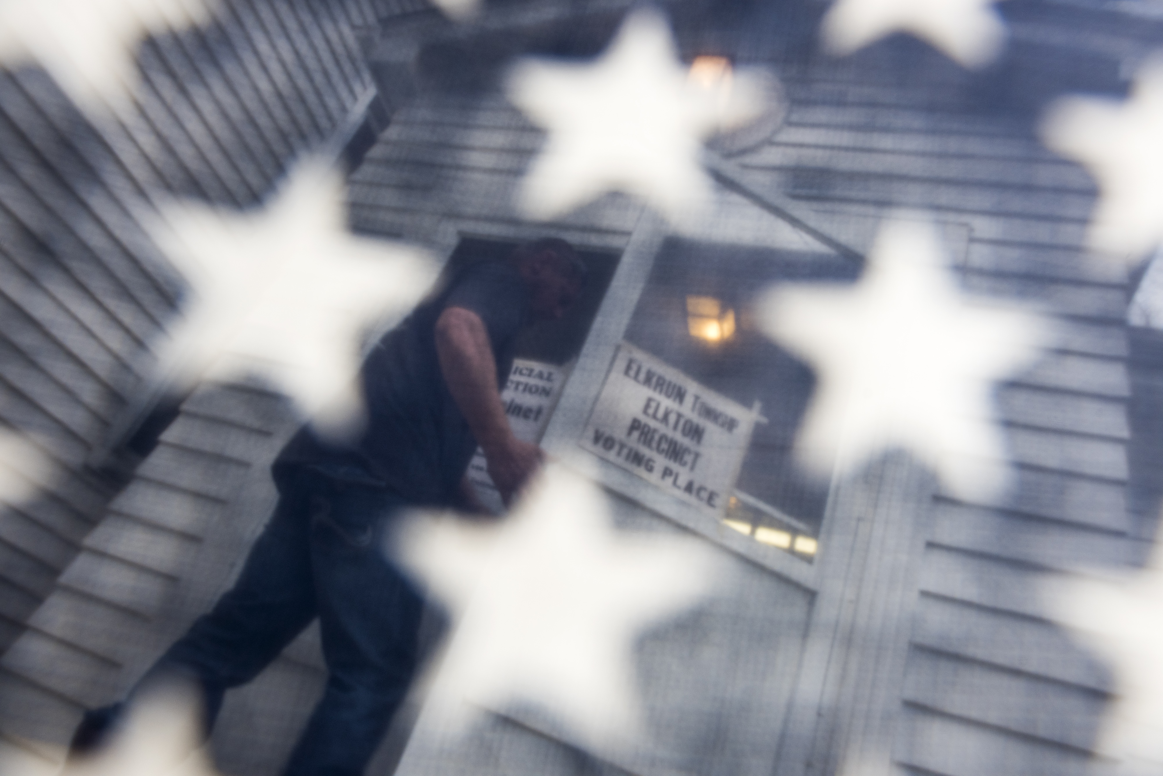 A voter is seen through an American Flag as he walks into cast his ballots at the Elton Methodist Church on November 8, 2016 in Elkton, Ohio. (Photo by Ty Wright/Getty Images)