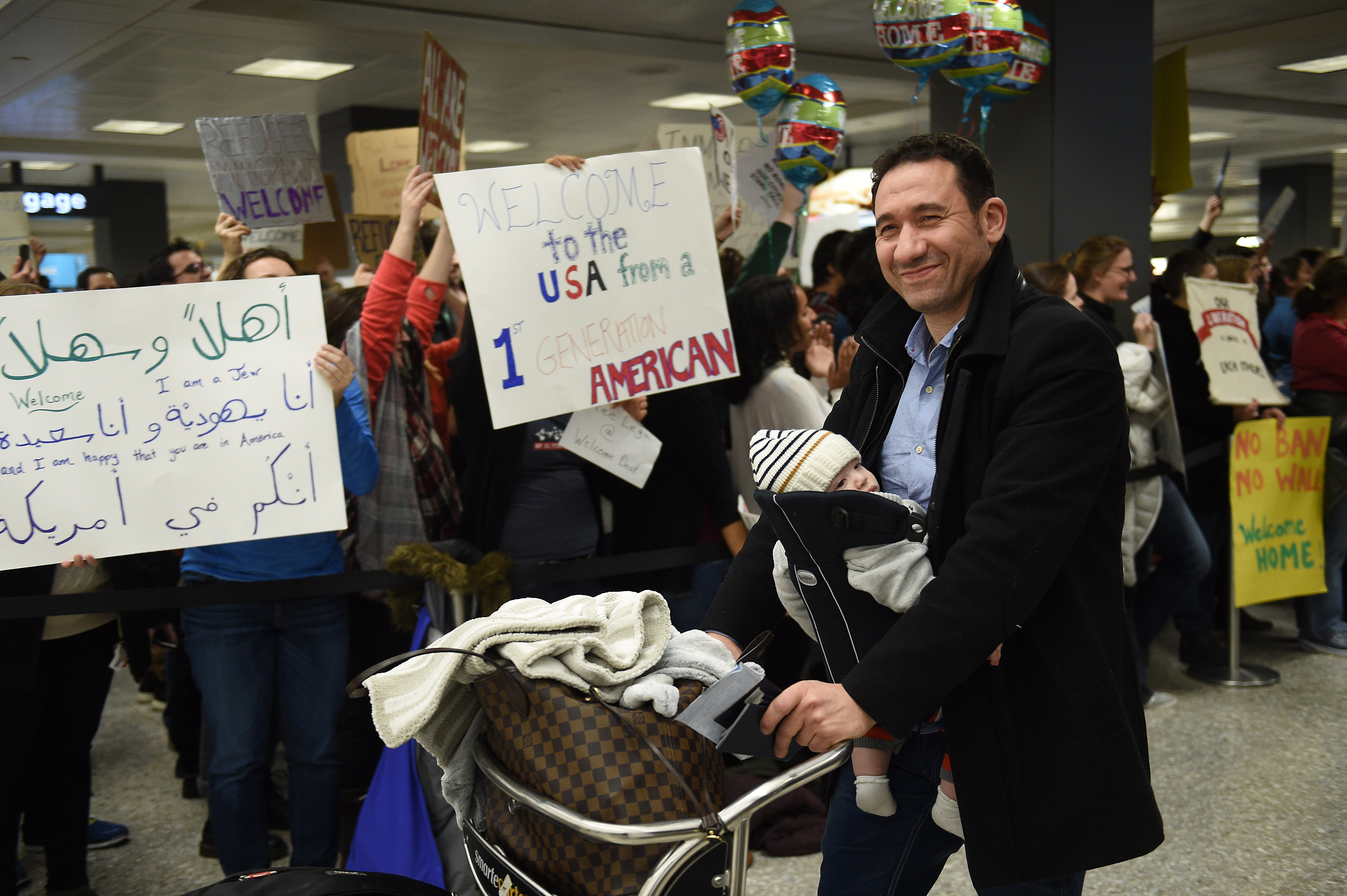 DULLES, VA - JANUARY 28: People protest and welcome arriving passengers at Washington Dulles International Airport in Virginia, January 28, 2017. The protest follows the executive order of President Donald Trump to bar all refugees coming to the US and Muslims from seven countries. (Photo by Astrid Riecken For The Washington Post via Getty Images)