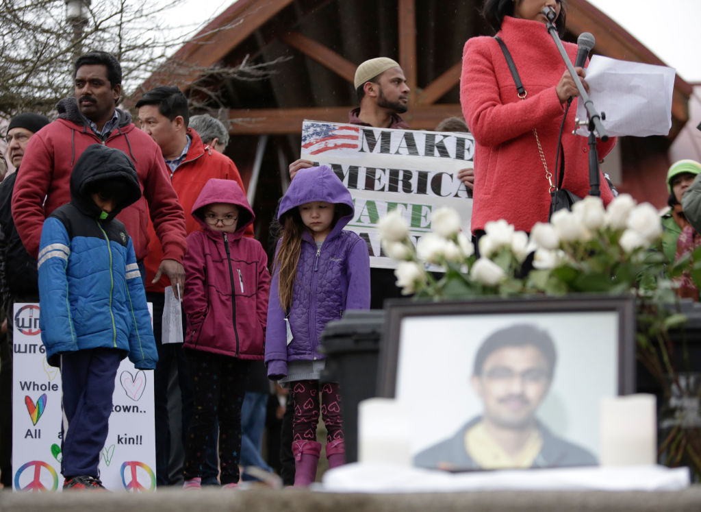 People gather near a photograph of Srinivas Kuchibhotla, the 32-year-old Indian engineer killed at a bar Olathe, Kansas, during a peace vigil in Bellevue, Washington on March 5, 2017. CREDIT: JASON REDMOND/AFP/Getty Images