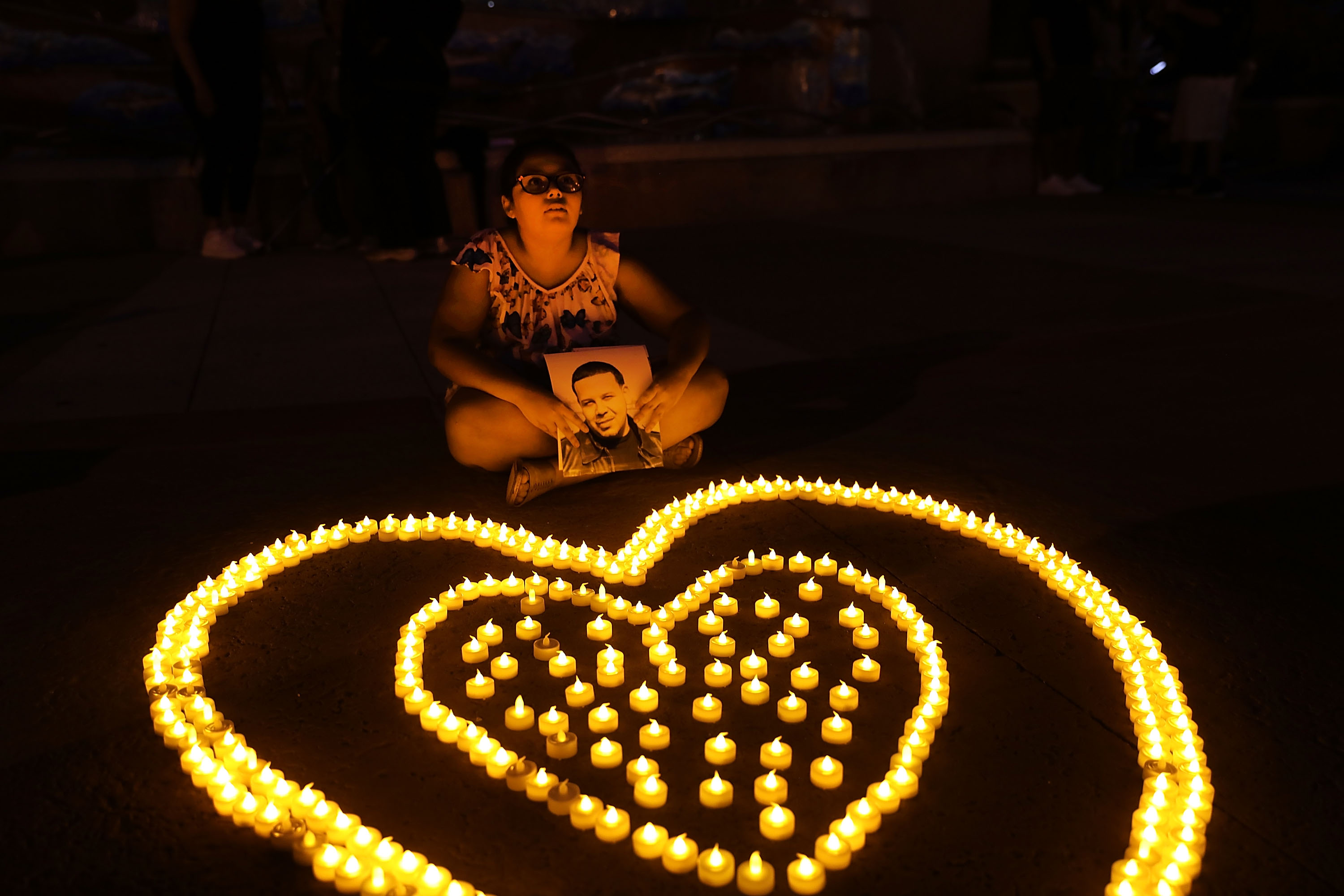 A nine-year-old girl holds up a picture of a family member who died from a heroin overdose during a candlelight vigil for victims of drug addiction on August 24, 2017 in New York City. CREDIT: Spencer Platt/Getty Images