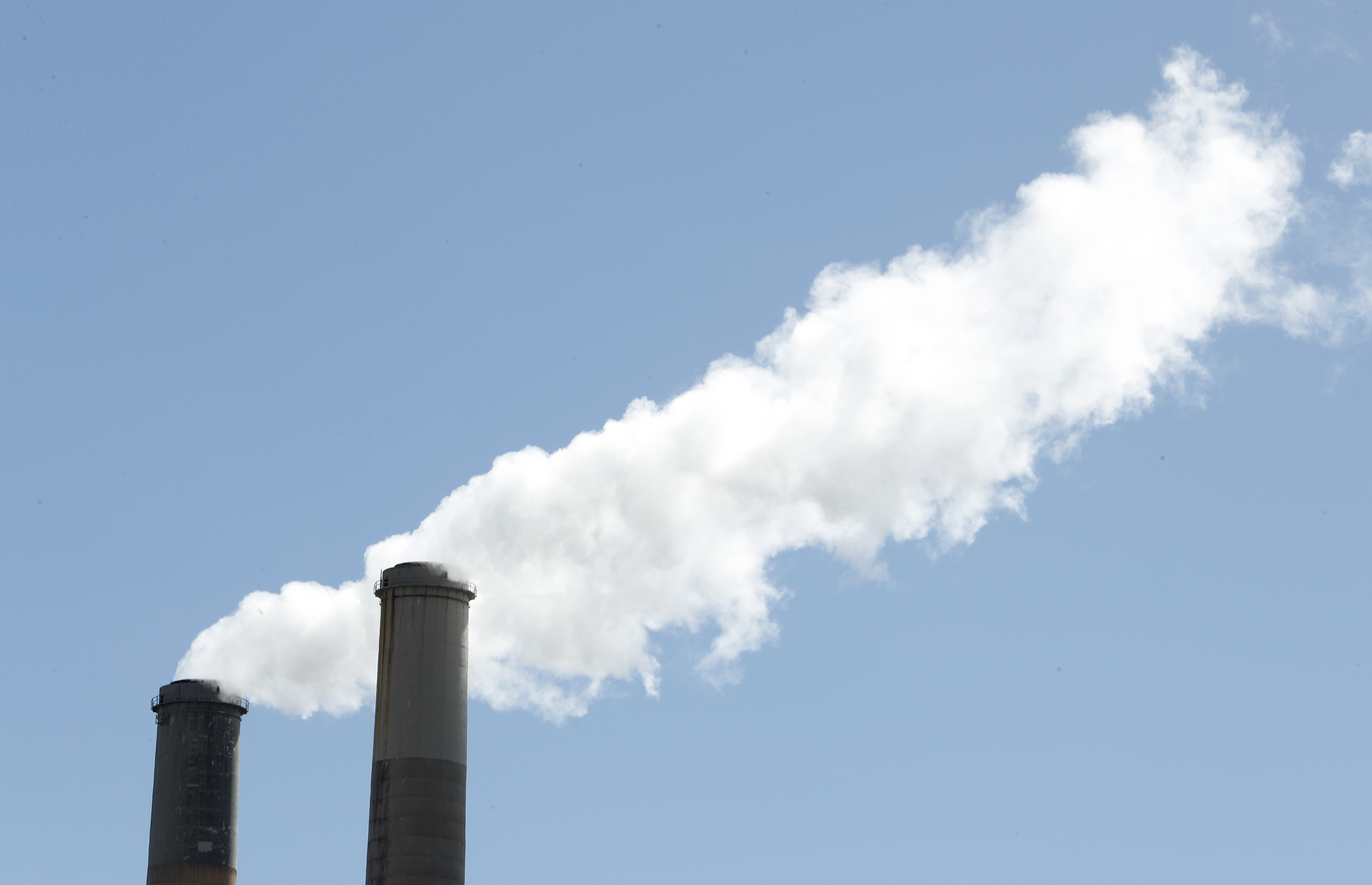 Emissions rise out of two large smoke stacks at a coal-fired power plant. (CREDIT: George Frey/Getty Images)
