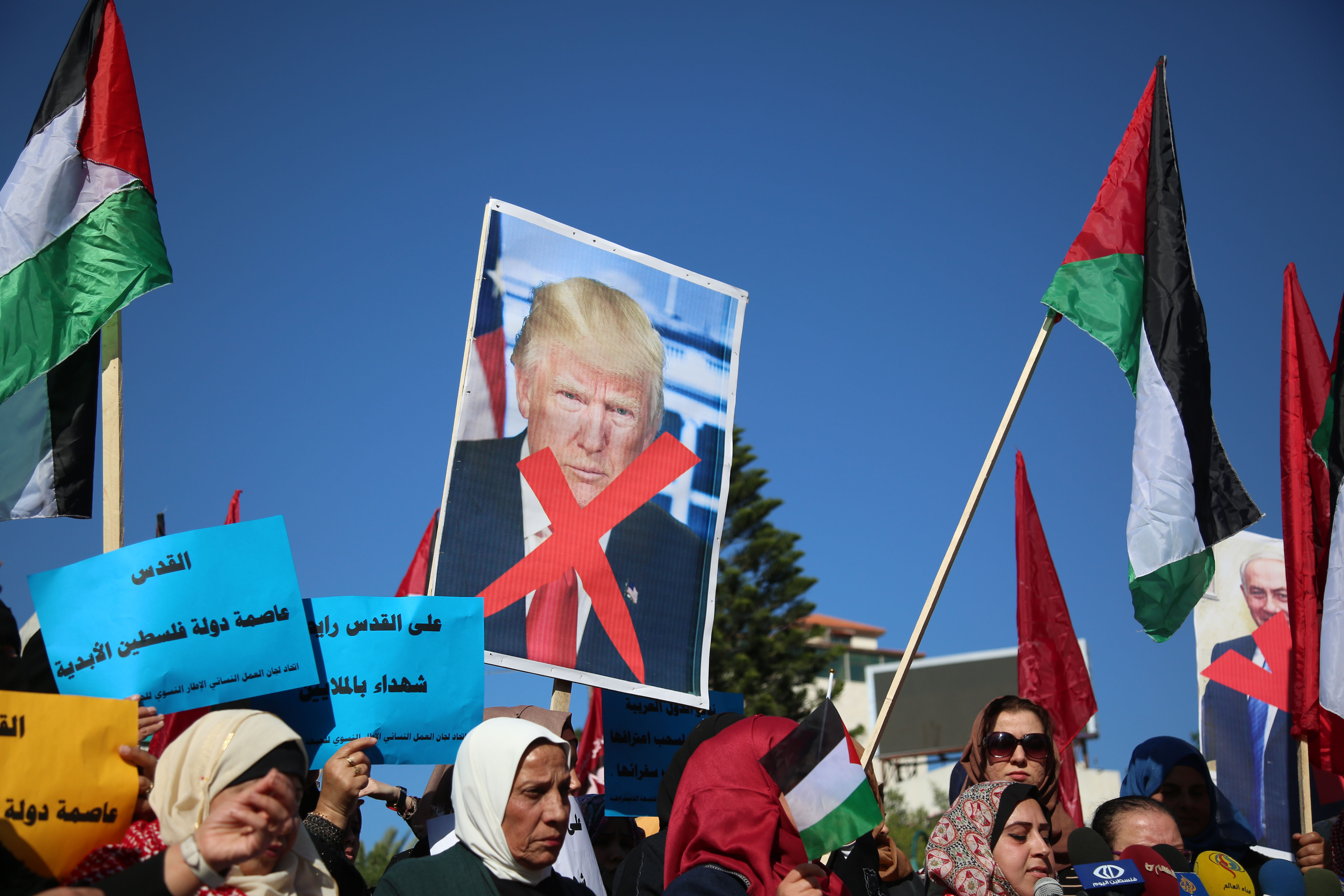 Palestinian women hold banners during a protest against US President Donald Trump's decision to recognise Jerusalem as the capital of Israel, in Gaza City. CREDIT: Majdi Fathi/NurPhoto via Getty Images.