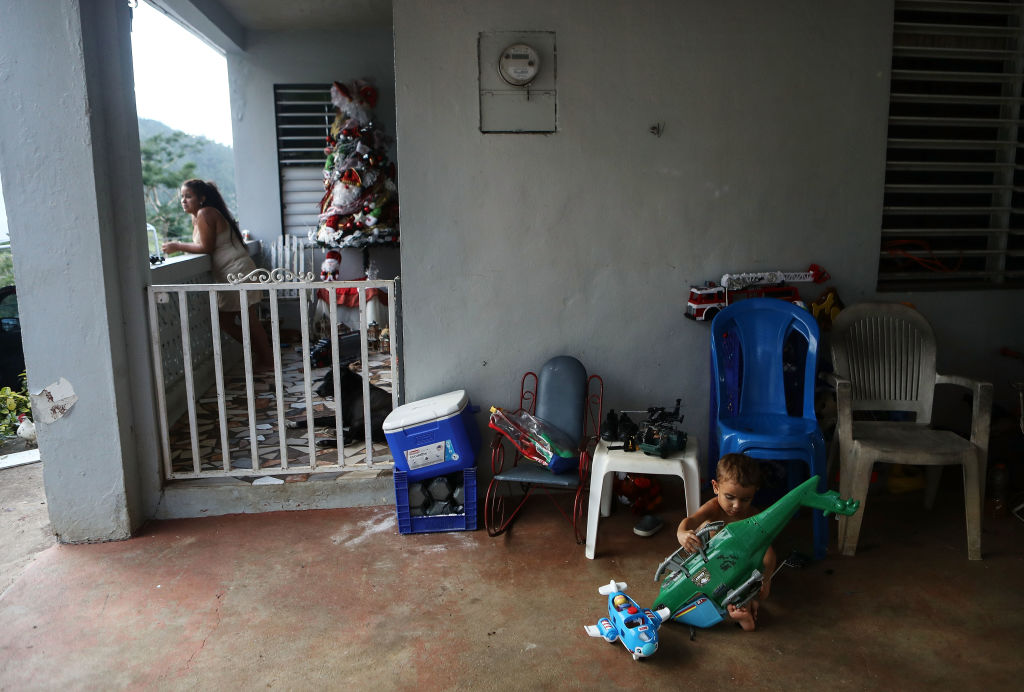 Young residents gather at their family's home, still without electricity, on Christmas day on December 25, 2017 in Morovis, Puerto Rico. Thirty percent of the devastated island is still without electricity. (CREDIT: Mario Tama/Getty Images)