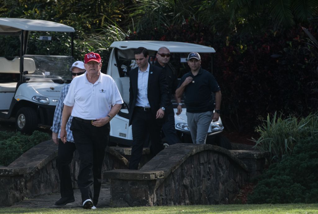 US President Donald Trump walks onto the green at the Trump International Golf Course in Mar-a-Lago, Florida during an invitation for United States Coast Guard service members to play golf on December 29, 2017. CREDIT: NICHOLAS KAMM/AFP/Getty Images