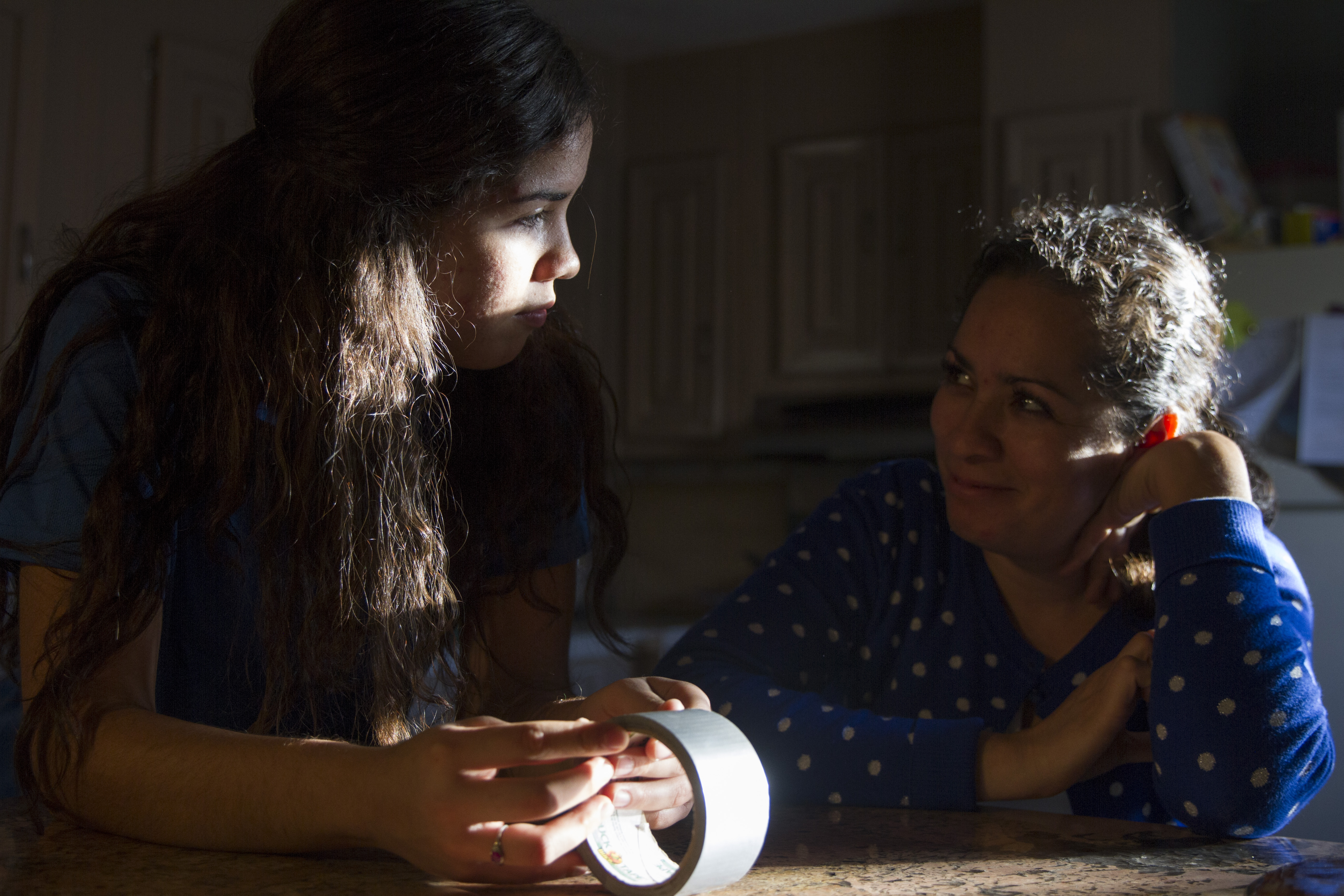 Pena, and her mom, Haidee, exchange a glance at their Paradise Valley trailer home as her two younger brothers play on Oct. 10, 2017. (Credit: Megan Janetsky)