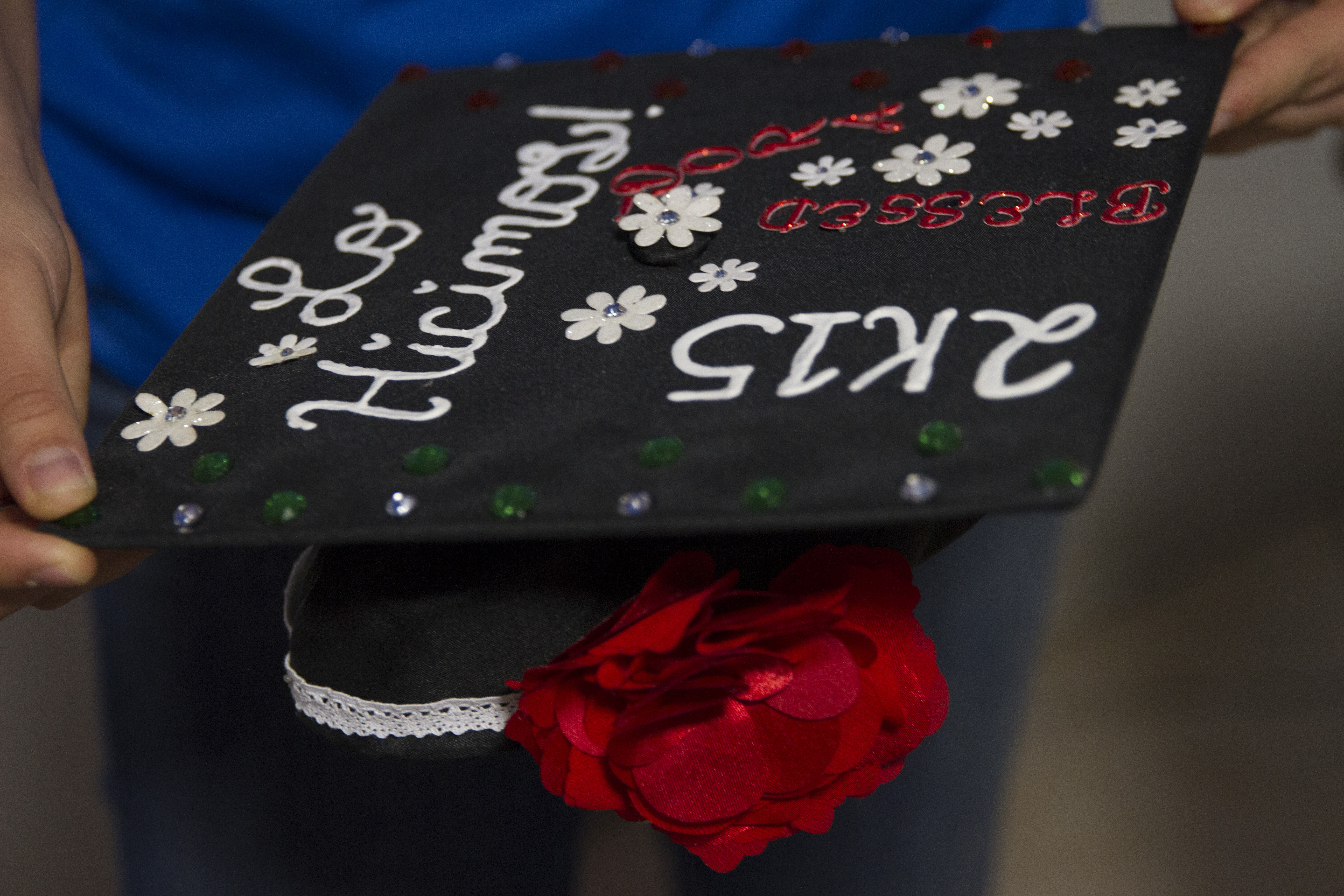 Maria holds her high school graduation cap. It reads "Lo Hicimos!" or "We did it!" She decorated the cap with red, white and green, representing the colors of Mexico. (Credit: Megan Janetsky)