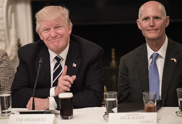 Political observers accuse Florida Gov. Rick Scott (R), right, of receiving special treatment from the Trump administration to benefit the governor's political ambitions. CREDIT: NICHOLAS KAMM/AFP/Getty Images
