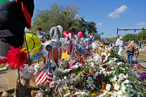 Mourners bring flowers as they pay tribute at a memorial for the victims of the shooting at Marjory Stoneman Douglas High School on Sunday, February 25, 2018. (David Santiago/Miami Herald/TNS via Getty Images)