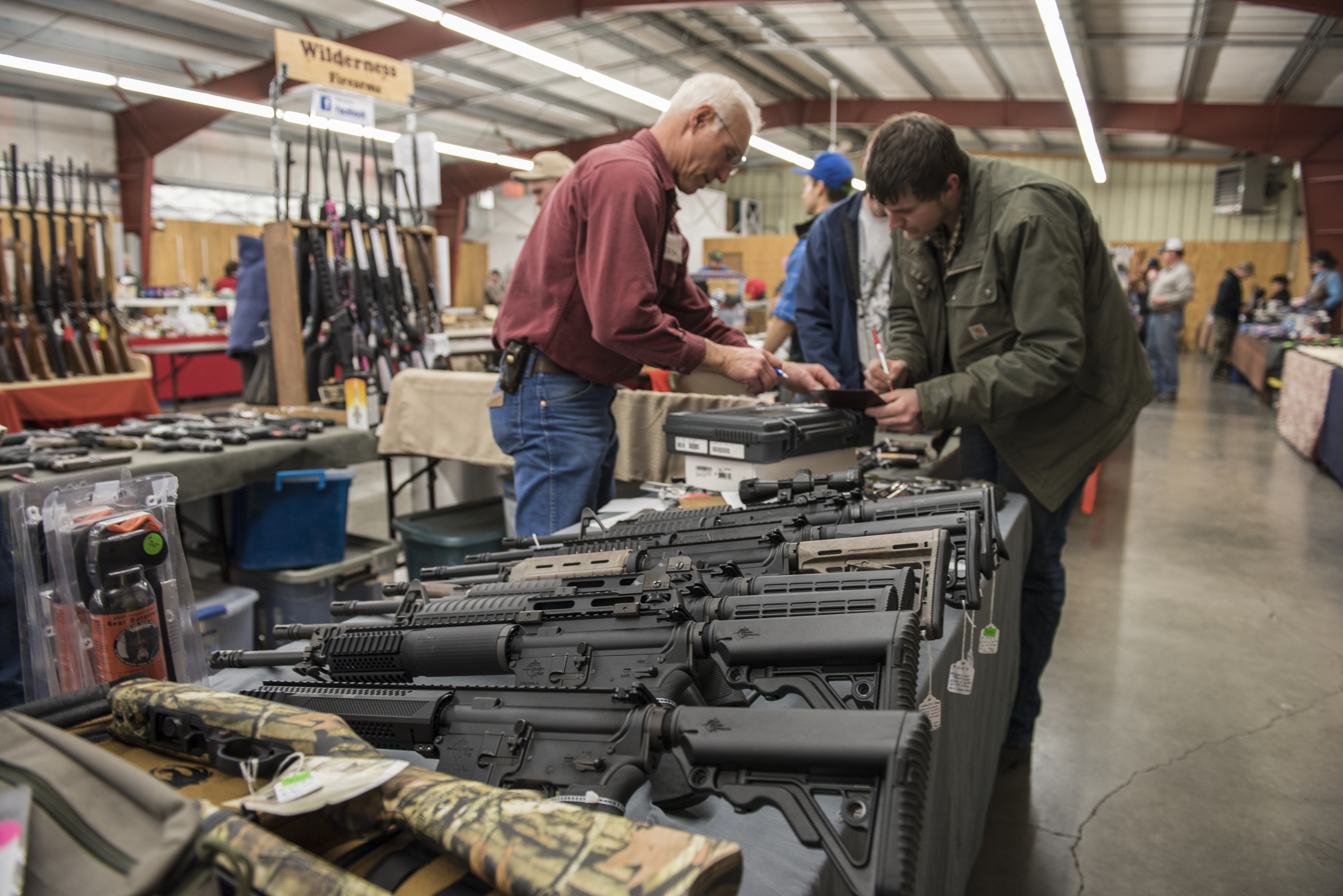 A licensed gun dealer does a federal background check for a potential buyer during a gun show in Livingston, Montana. New data shows the FBI could not complete 310,232 federal background checks within the three-business-day deadline last year. CREDIT: William Campbell/Corbis via Getty Images