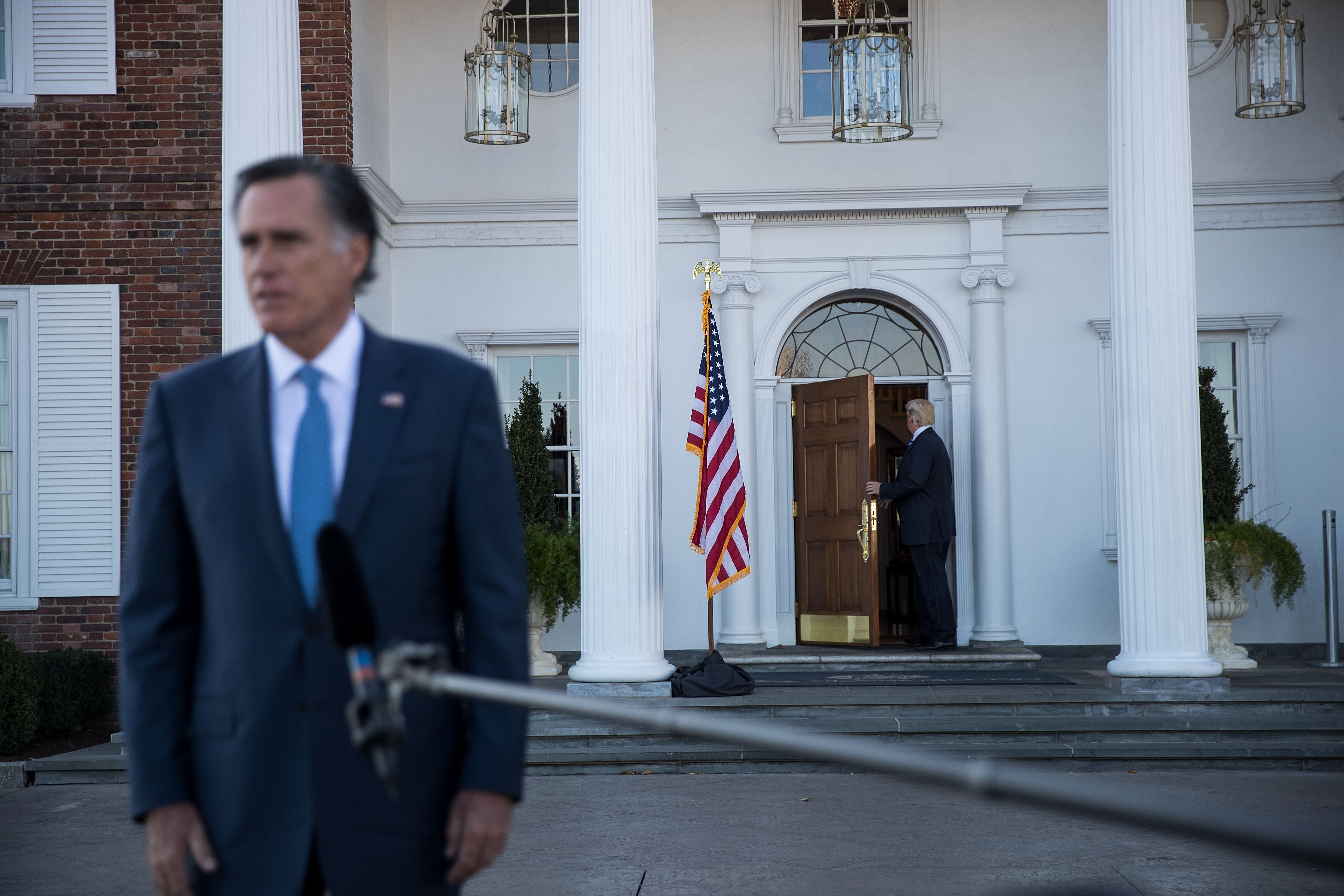 President-elect Donald Trump (R) walks back inside the clubhouse as Mitt Romney speaks to reporters after their meeting at Trump International Golf Club, November 19, 2016 in Bedminster Township, New Jersey. CREDIT: Photo by Drew Angerer/Getty Images