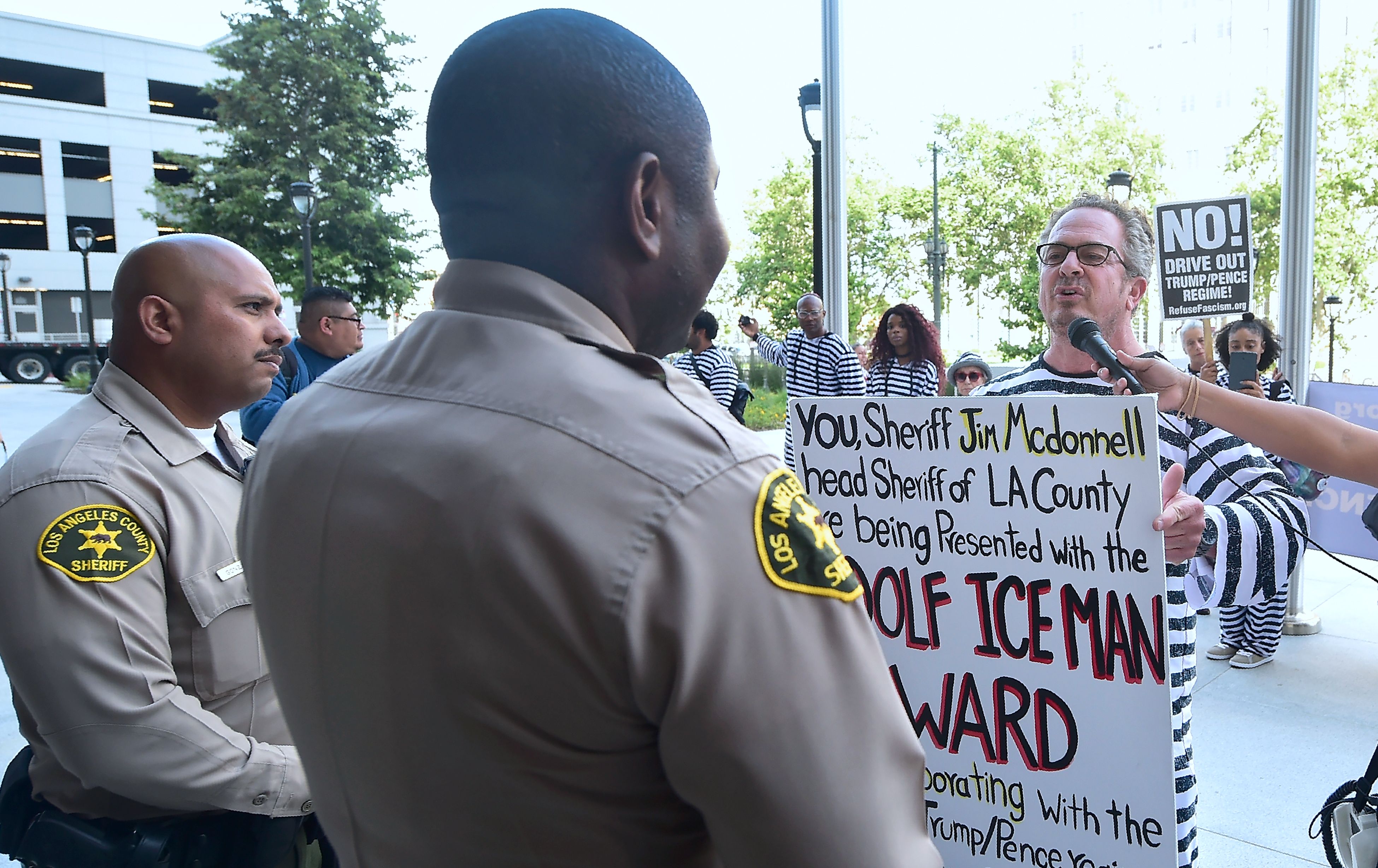 Activists dressed in prisoner outfits deliver a placard to deputies manning the Los Angeles Sheriff's Department in protest of US immigration policy in April 2017 in Los Angeles, California. CREDIT: FREDERIC J. BROWN/AFP/Getty Images