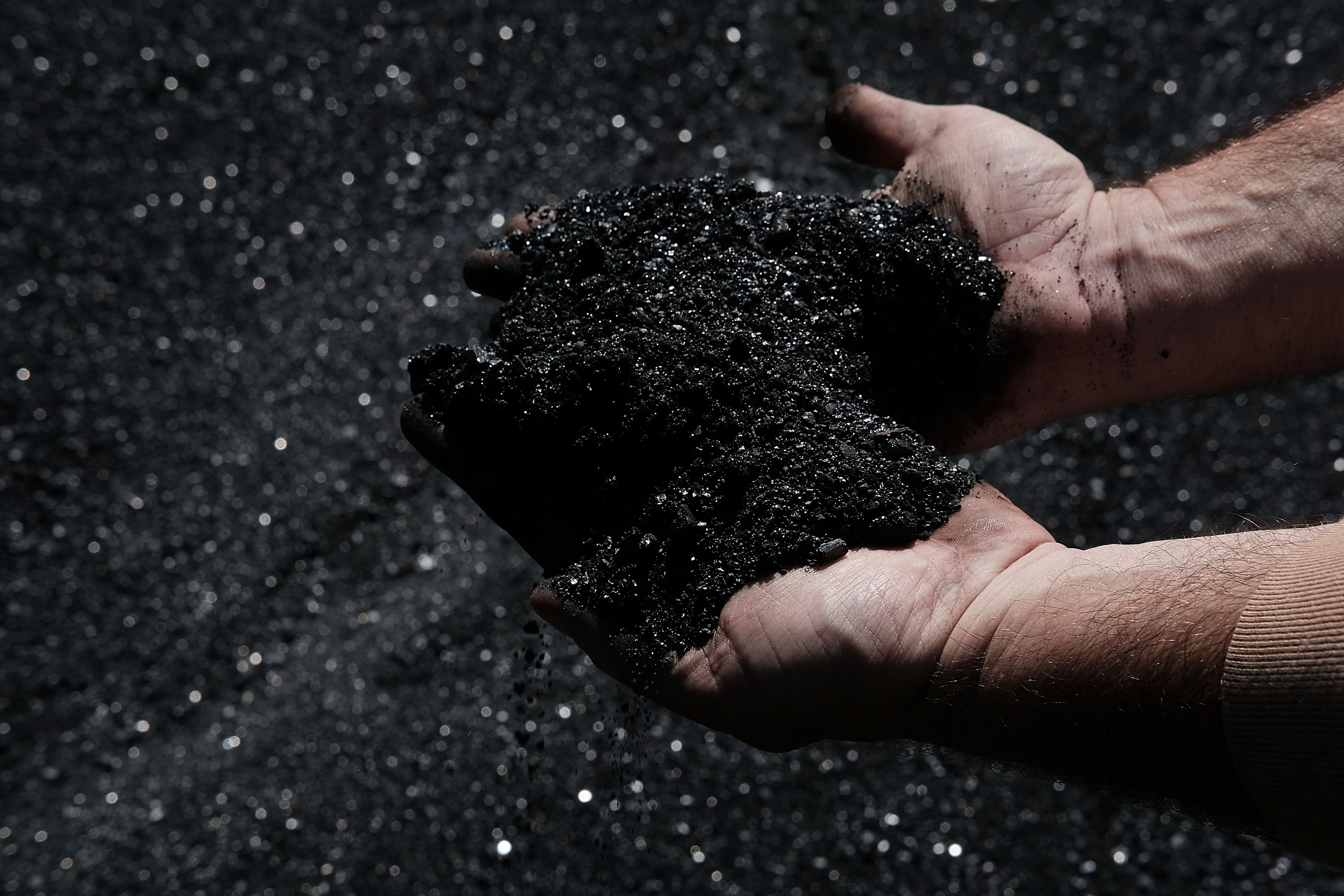 A worker in the coal industry handles coal. (CREDIT: Spencer Platt/Getty Images)