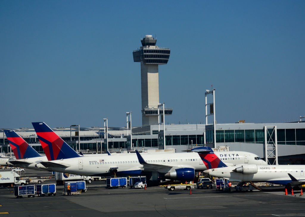 Delta Airlines Boeing 777 passenger jets are serviced at John F. Kennedy International Airport in New York, New York, with the airport's 32 story, 321-foot tall control tower in the background. (CREDIT: Robert Alexander/Getty Images)