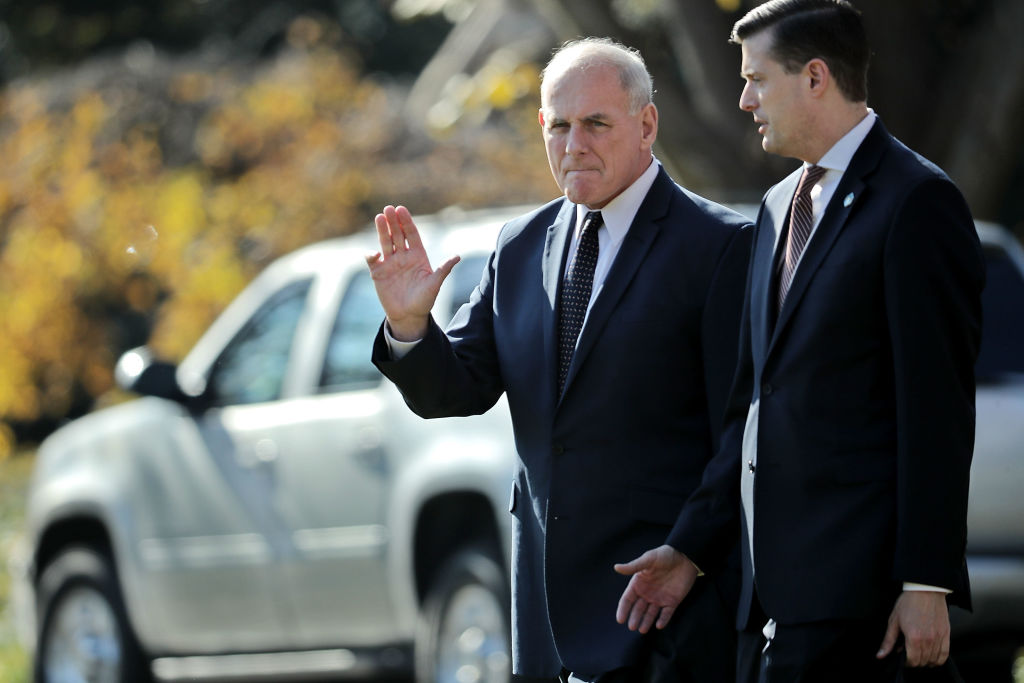 White House Chief of Staff John Kelly (L) waves to journalists as he and Staff Secretary Rob Porter leave the White House with U.S. President Donald Trump November 29, 2017 in Washington, DC. (CREDIT: Photo by Chip Somodevilla/Getty Images)