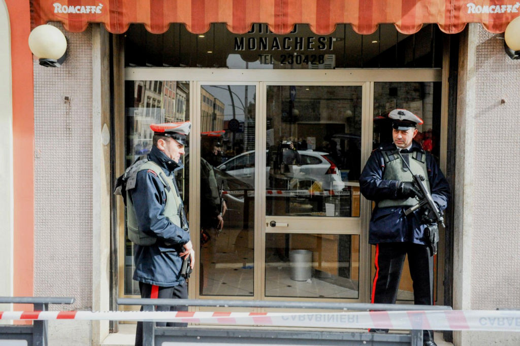 Police officers stand guard as forensics officers carry out investigations in the area following the wounding of several foreign nationals in a drive-by shooting at Macerata, on February 3, 2018. CREDIT: STR/AFP/Getty Images