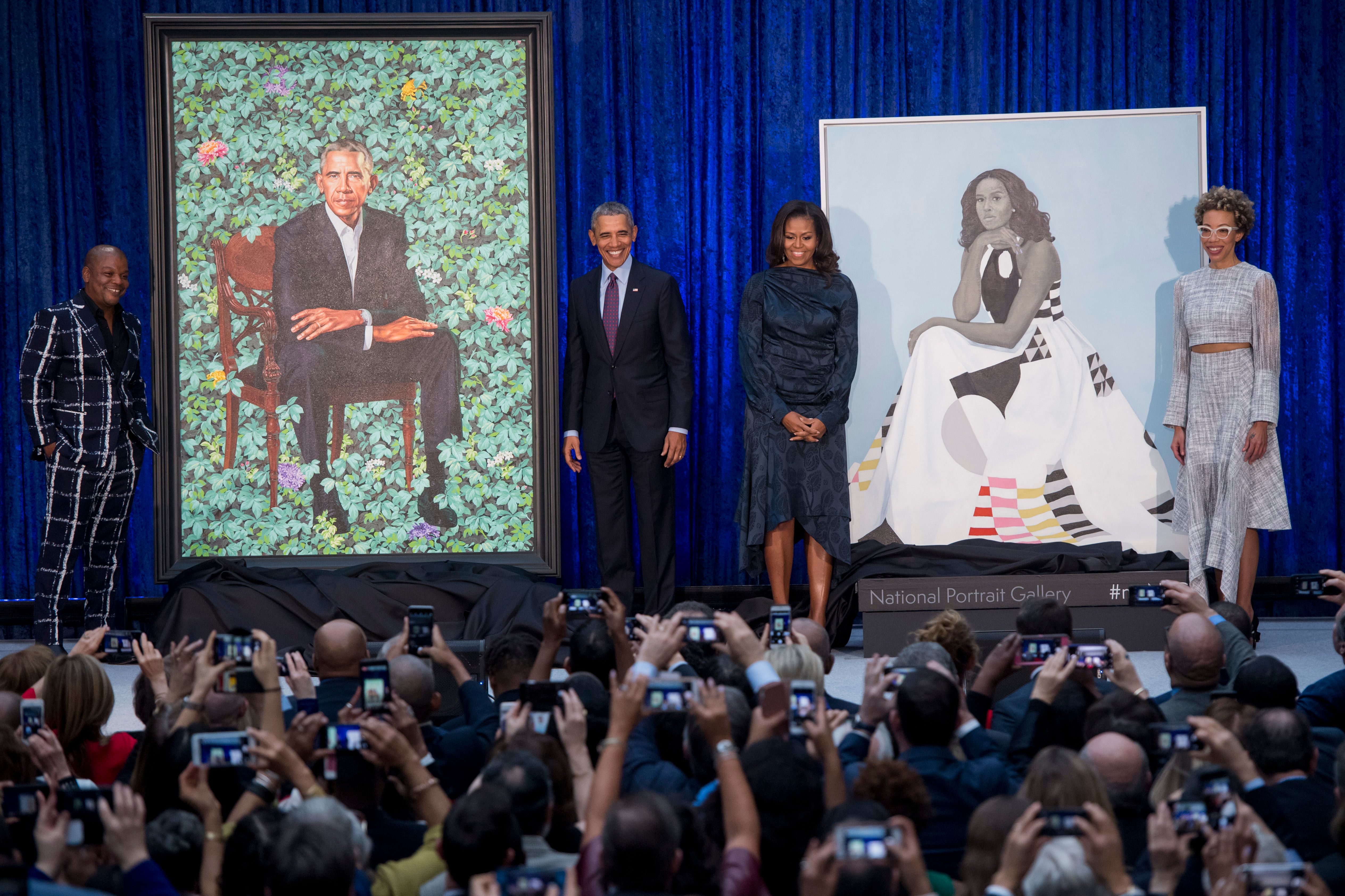 Former President Barack Obama and First Lady Michelle Obama stand before their portraits and respective artists, Kehinde Wiley (L) and Amy Sherald (R), after an unveiling at the Smithsonian's National Portrait Gallery in Washington, DC, February 12, 2018. CREDIT: SAUL LOEB/AFP/Getty Images