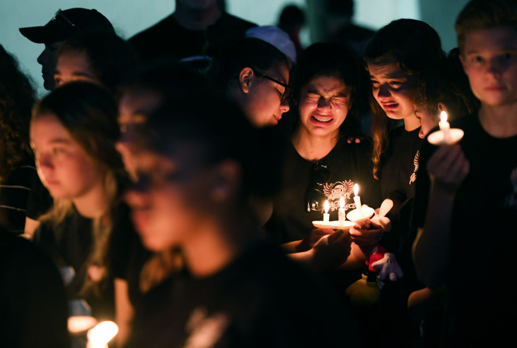 PARKLAND, FL - FEBRUARY 15: Marianna Guttierez, 14, center, and other students of Marjory Stoneman Douglas High School gather with others for a candlelight vigil in honor of the victims of the school shooting on Thursday February 15, 2018 in Parkland, FL. (Photo by Matt McClain/The Washington Post via Getty Images)