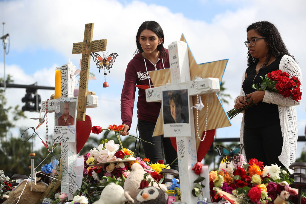 Marissa Rodriguez and Ambar Ramirez visit a makeshift memorial setup in front of Marjory Stoneman Douglas High School. CREDIT: Getty Images