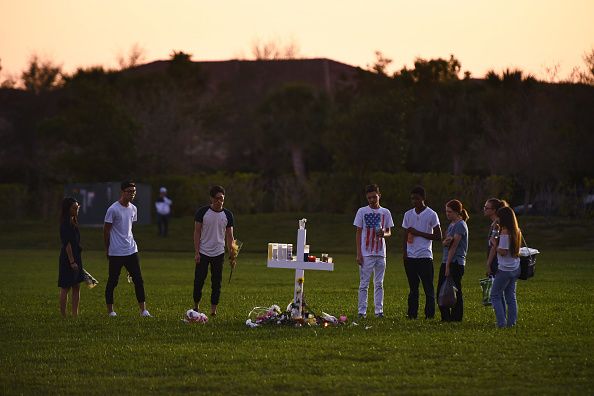 On February 16, 2018, young people visit a makeshift memorial for the victims of the Marjory Stoneman Douglas High School massacre in Parkland, Florida. CREDIT: Matt McClain/The Washington Post via Getty Images