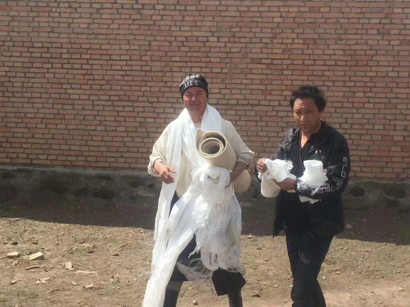 Tibetan blogger Drukar Gyal, left, and fellow writer Therang walk together in the days after Gyal's release from a Chinese prison on March 19, 2018. Gyal wears white silk scarves — a mark of honor and respect in Tibetan culture. Under his arm, he carries a poem Therang wrote for him on white sheep felt, a Tibetan nomadic tradition. CREDIT: Photo provided by Golog Jigme