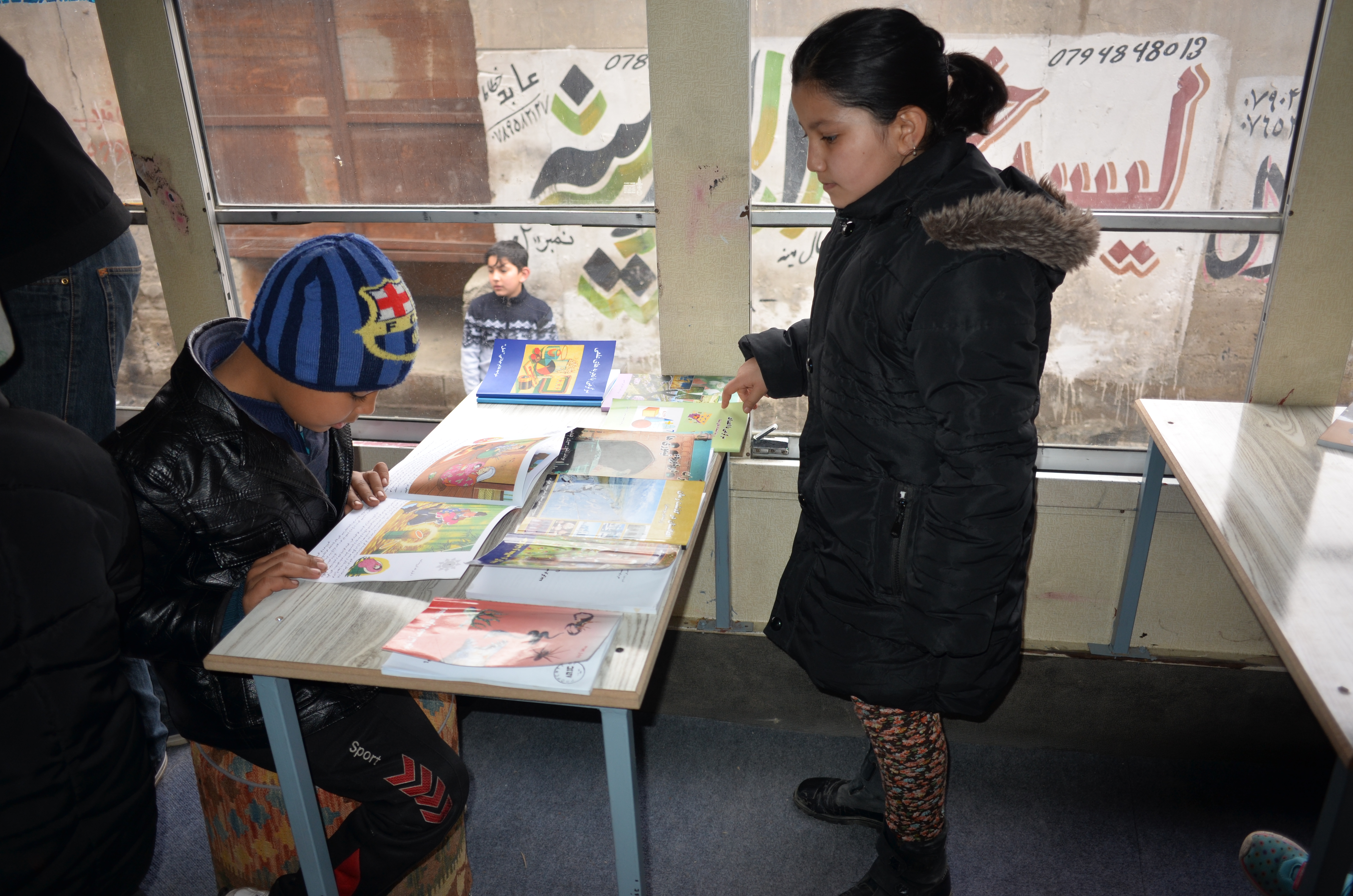 An Afghan girl selects a book at the Charmaghz library. (credit: Ali M. Latifi for ThinkProgress)