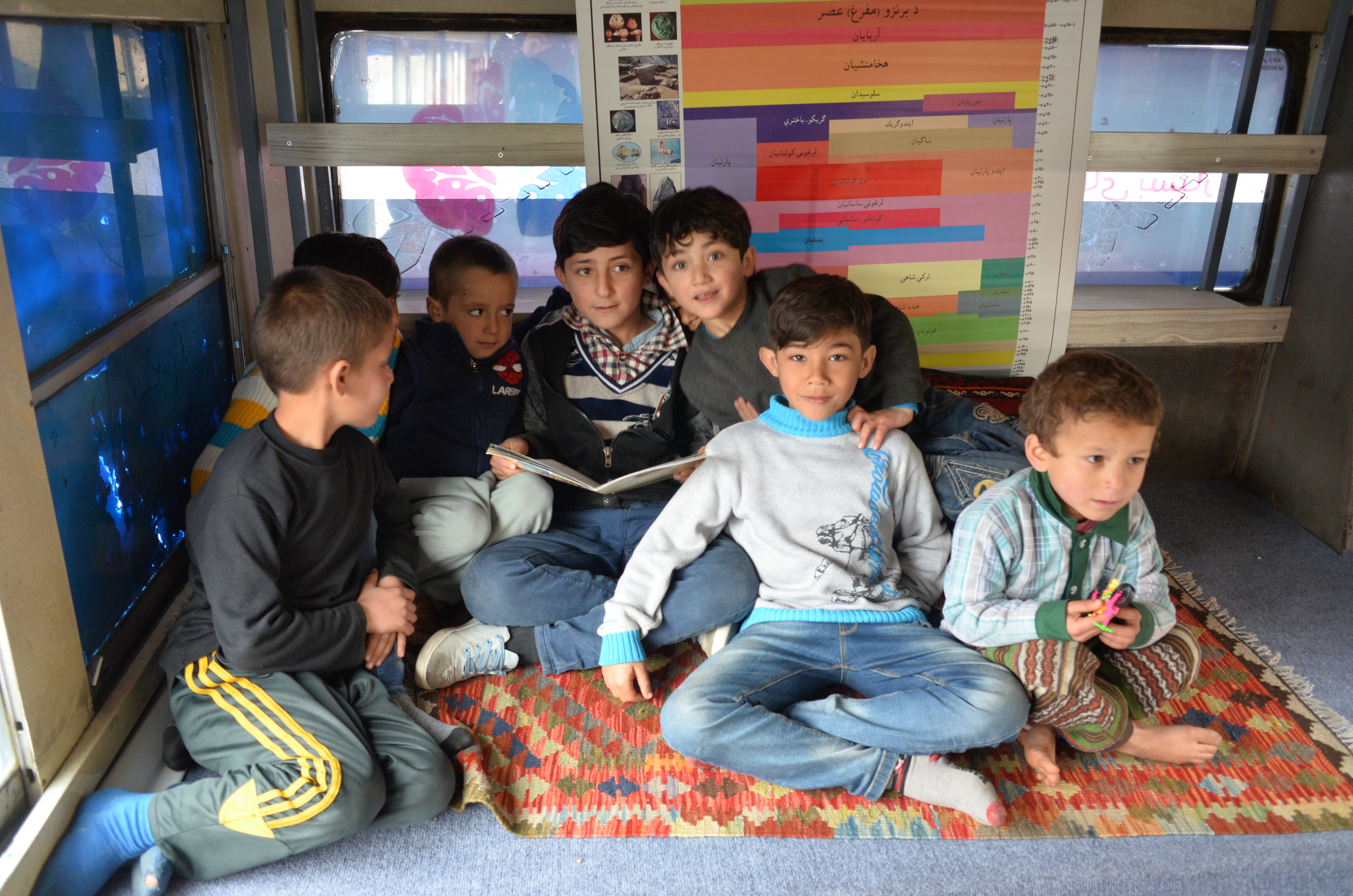 Afghan youth enjoy the Charmaghz mobile library in Kabul, Afghanistan. (Credit: Ali M. Latifi for ThinkProgress)