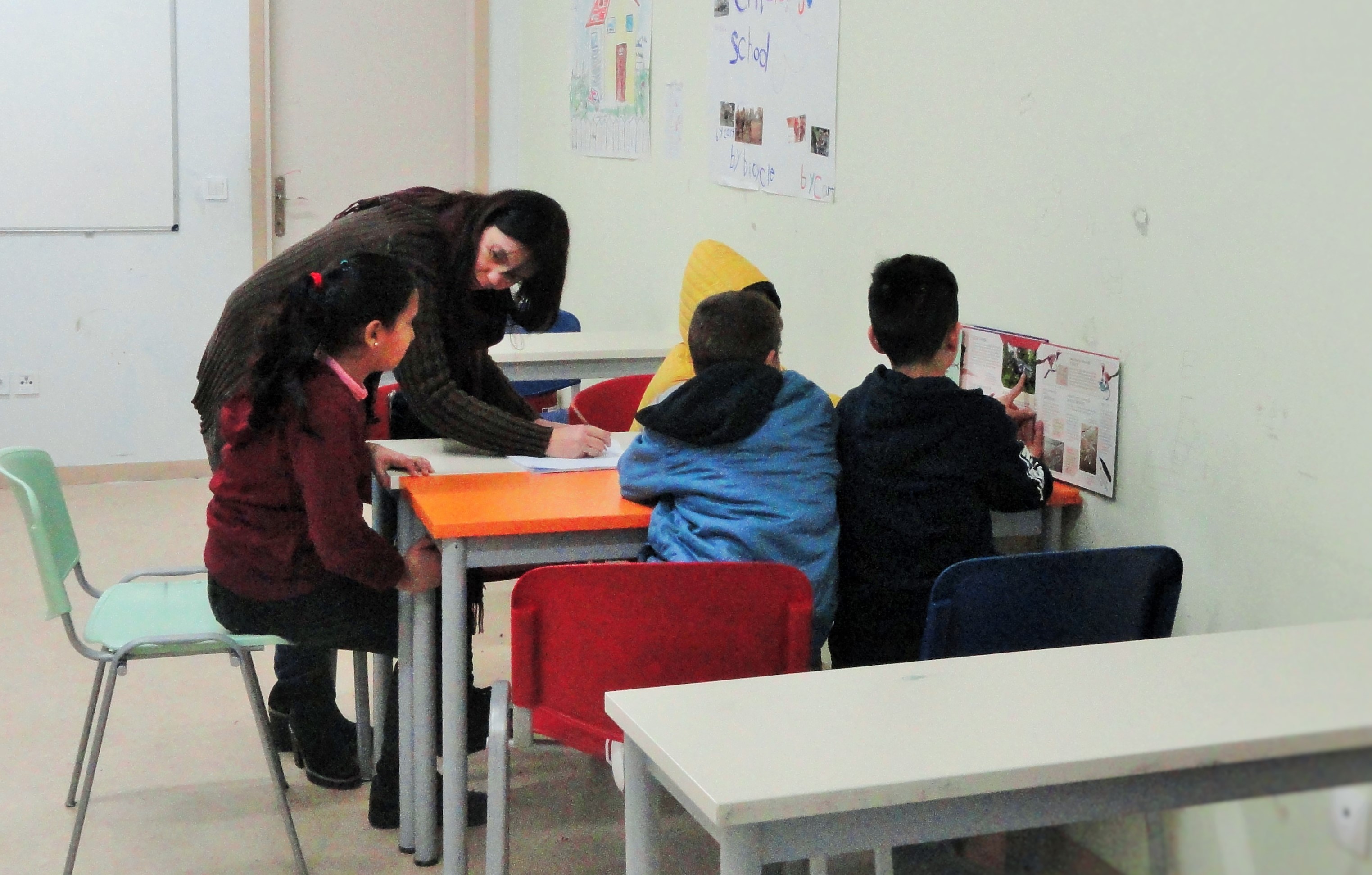 Children living a the Thiva asylum-seeker facility get a mid-day lesson on dinosaurs. Some of the children living there attend Greek schools on a strictly voluntary basis. CREDIT: D. Parvaz/ThinkProgress.