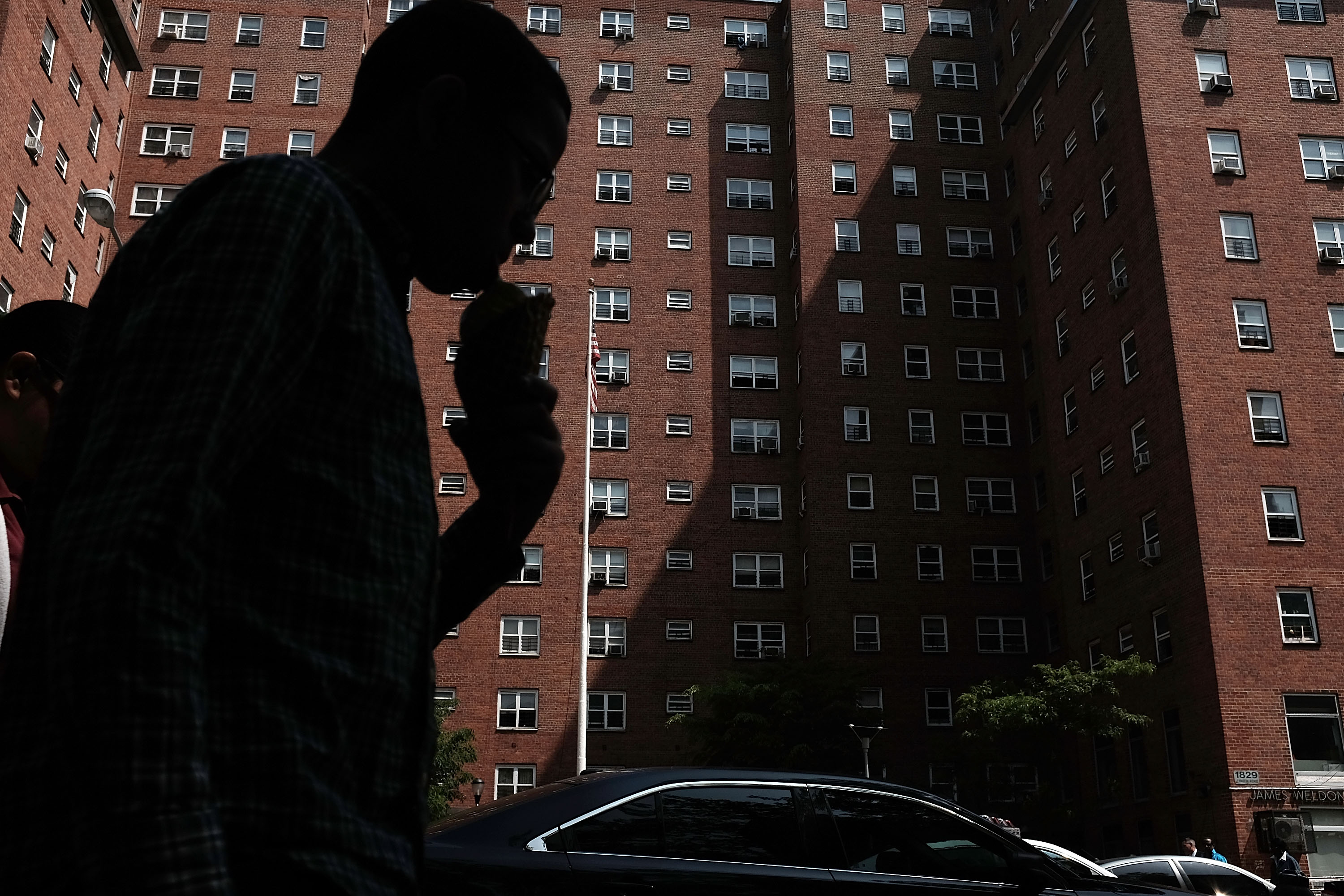 NEW YORK, NY - MAY 19: A person walks by an East Harlem public housing complex on May 19, 2015 in New York City. New York City Mayor Bill de Blasio announced his 10-year approach to fixing New York City's ailing public housing authority in an appearance Tuesday at the at Johnson Houses Community Center in Harlem. The plan will call for exploring the development of underused housing sites with mixed-income development. In the plan, half of any new residential units would be for low-income families. The New York City Housing Authority has an annual budget of about $3 billion and provides housing for more than 400,000 residents. (Photo by Spencer Platt/Getty Images)