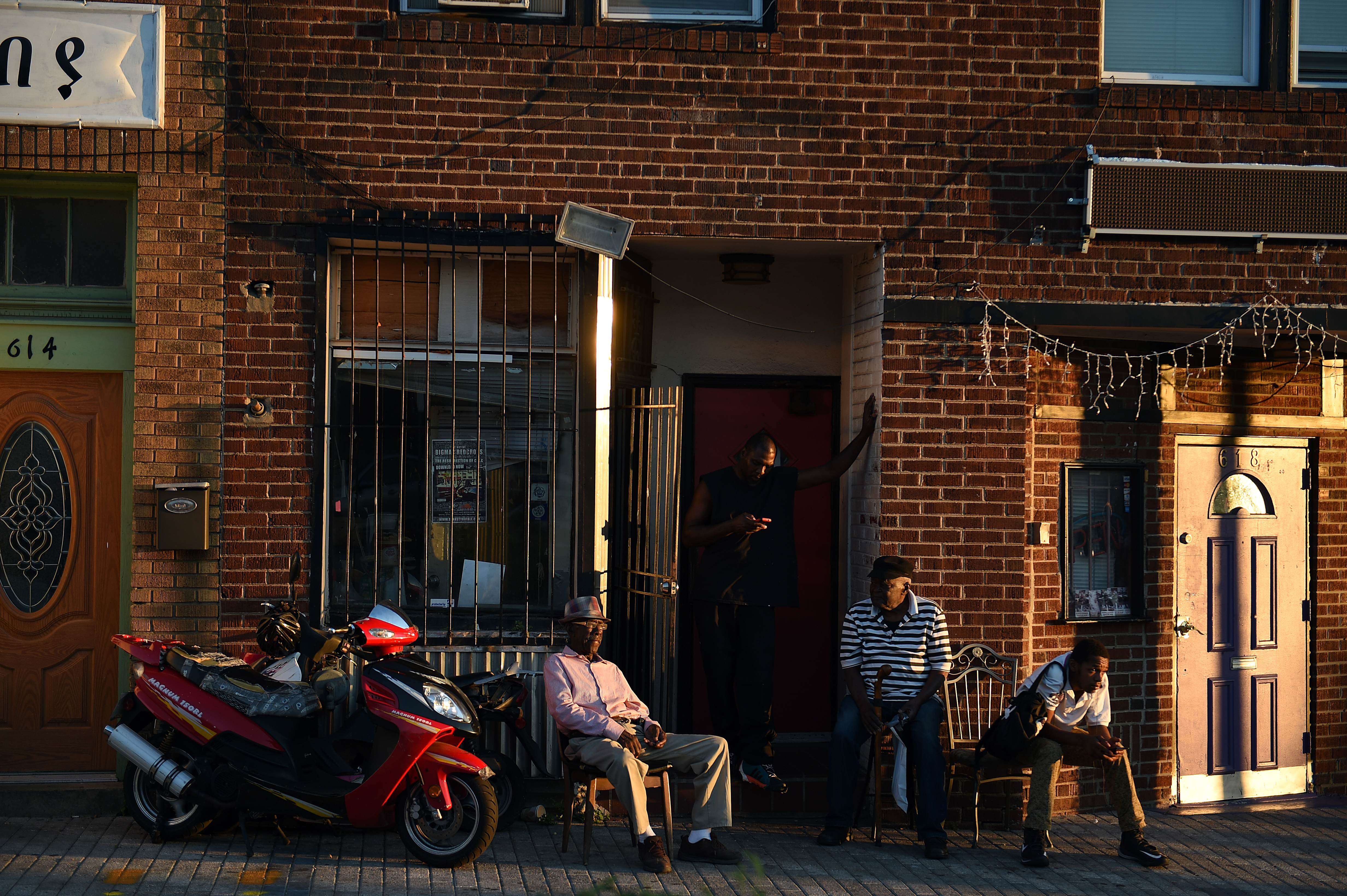 James Patterson, 79, left, a maintenance man, sits in front of his store near the Howard Theater, where he used to be the janitor, in the Shaw neighborhood in Washington, D.C., August 26, 2015. He is concerned about the lack of affordable housing in the neighborhood. (CREDIT: Astrid Riecken For The Washington Post via Getty Images)