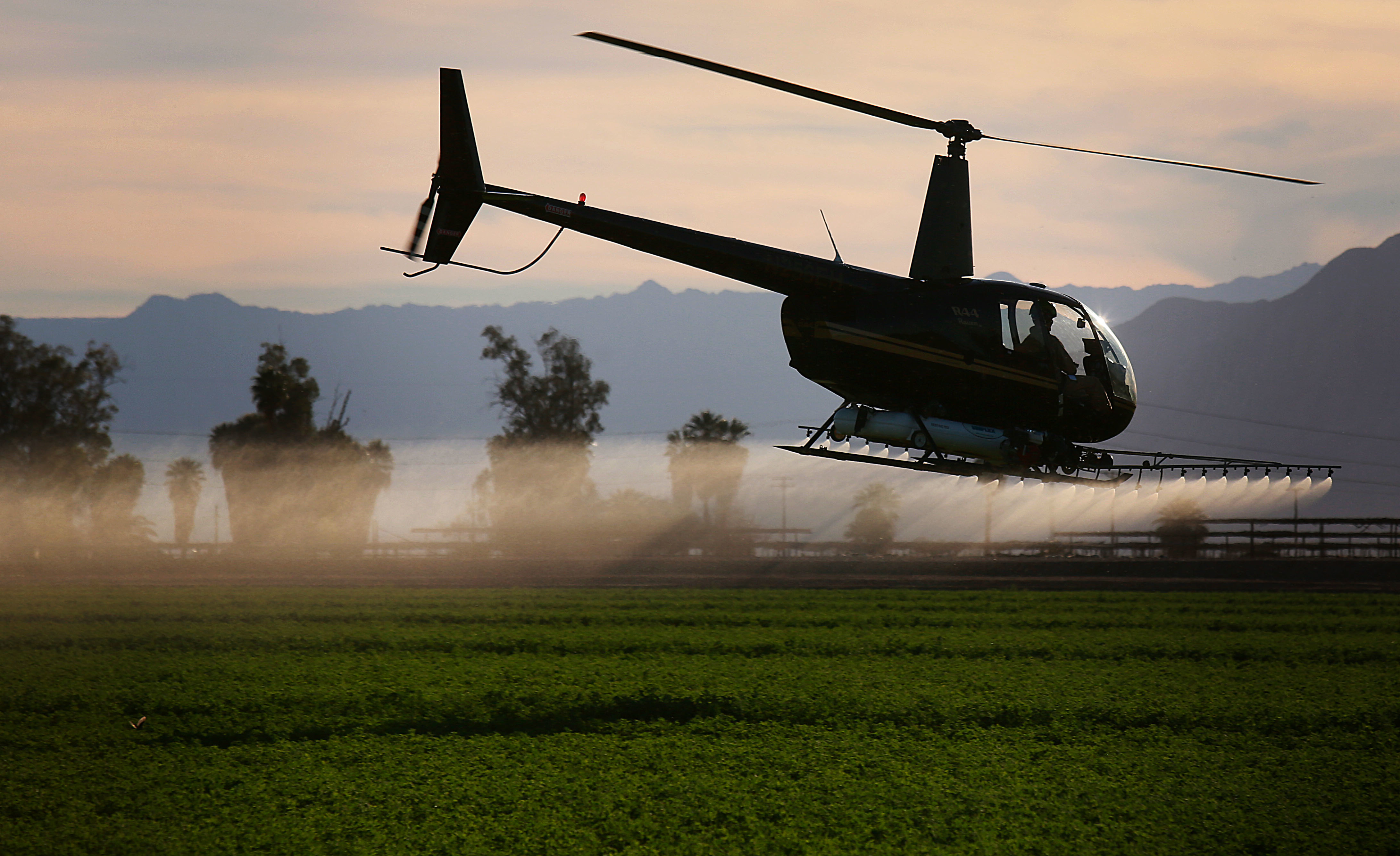 A helicopter sprays insecticide on a field outside of El Centro, California in the Imperial Valley on Wednesday, February 11, 2015. The Imperial Valley has some of the poorest air quality in California due to border traffic, farming and other industries. (CREDIT: Sandy Huffaker/Corbis via Getty Images)